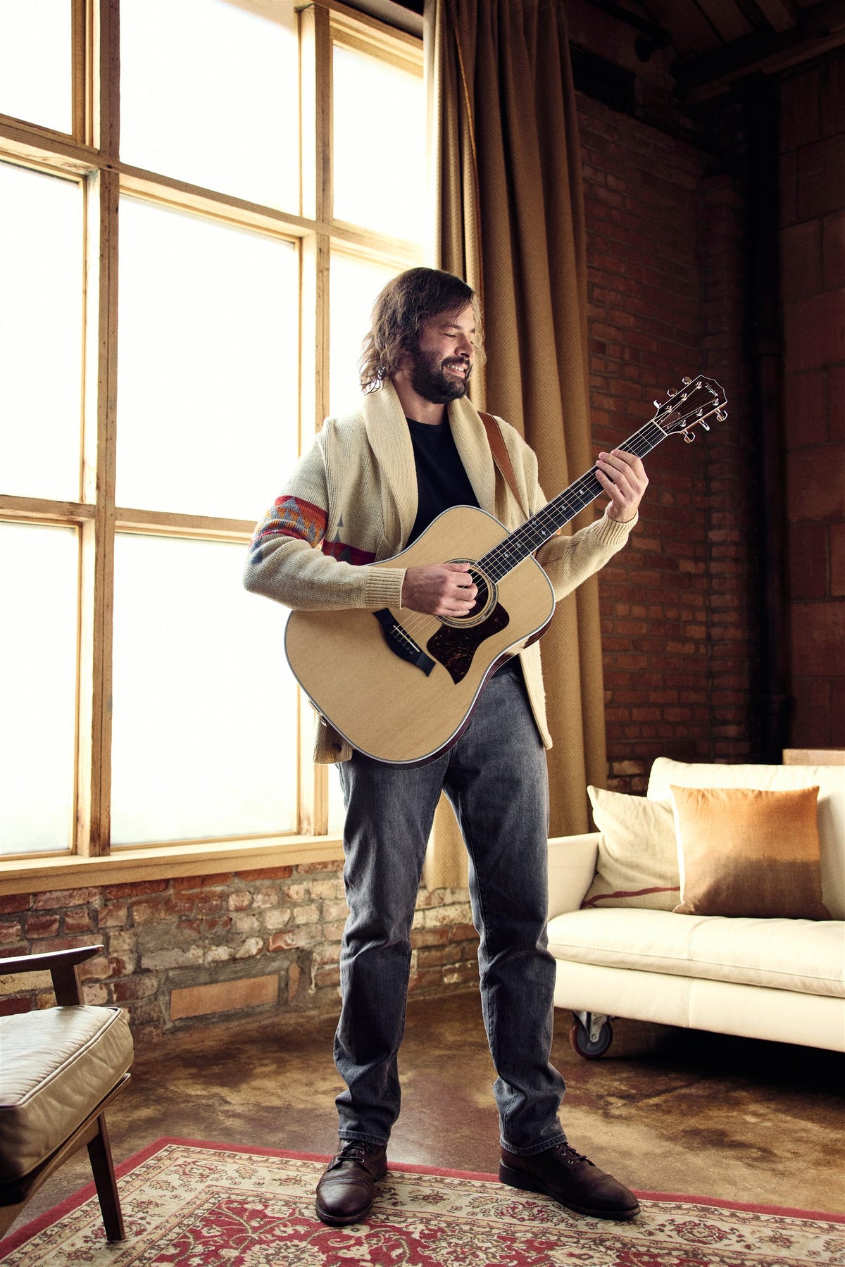 Taylor Legacy lifestyle photo — musician playing a Legacy 810e in a rustic loft, The Acoustic Shoppe