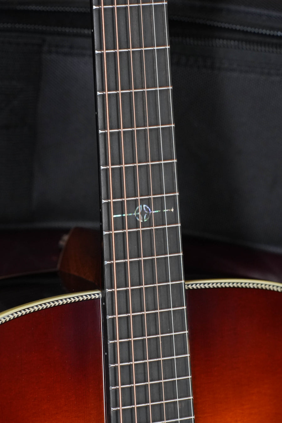 Close-up of the Alvarez LD70e Sitka/Rosewood Herringbone Sunset Dreadnought Guitar neck and fretboard, showcasing its unique twelfth-fret inlay and sunburst finish with a classic Sitka spruce top.