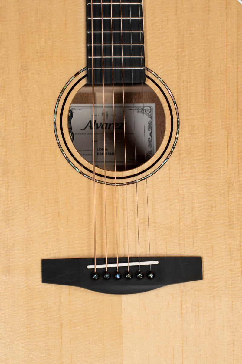 Close-up of an Alvarez Laureate Series LD60e Sitka/Mahogany Dreadnought Guitar w/LR Baggs Hifi Pickup, showing the strings, decorative soundhole inlay, part of the fretboard, and visible Alvarez label inside.