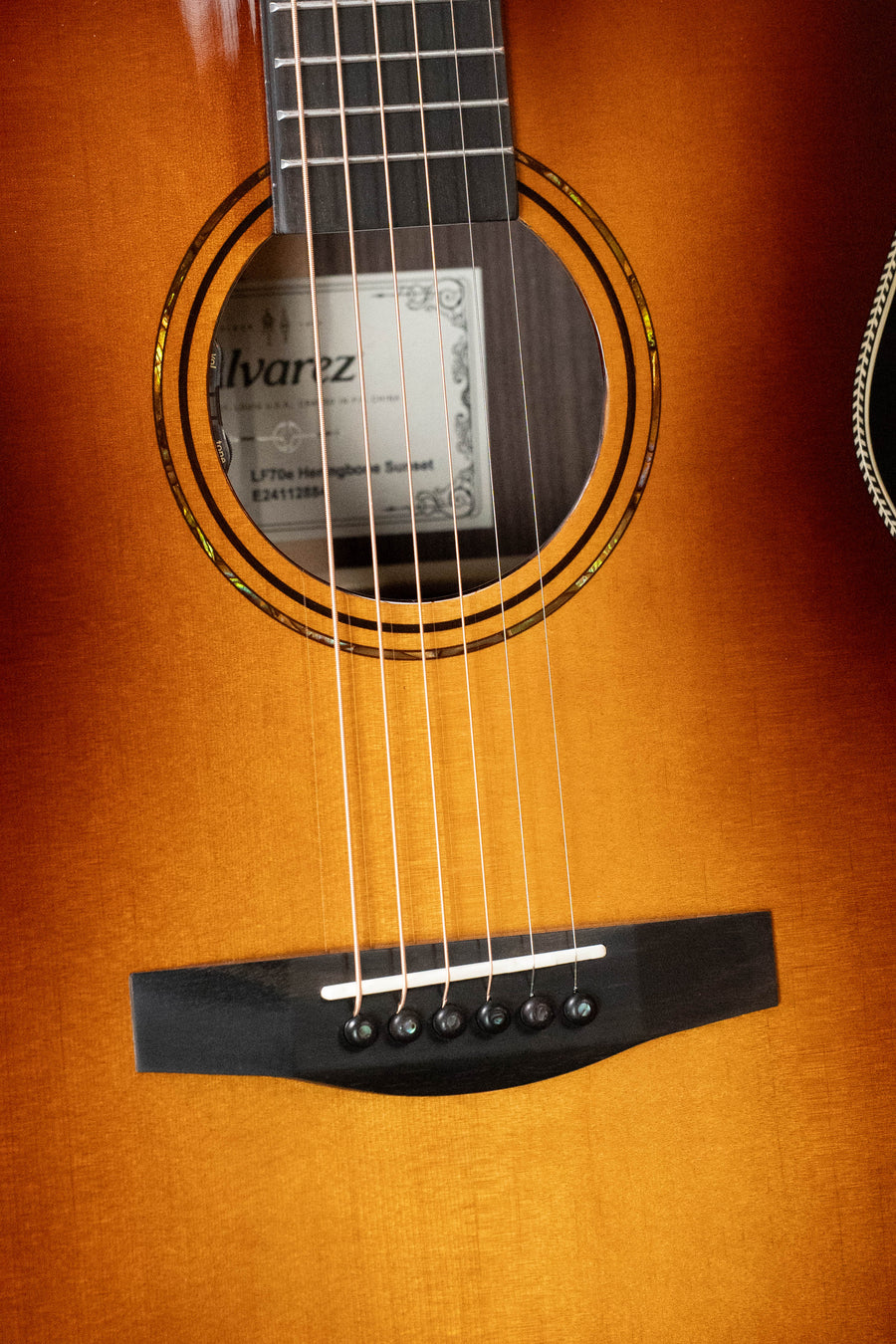 Sunset finish acoustic guitar with herringbone rosette and rosewood bridge, six strings visible. - Alvarez Laureate Series LF70e Herringbone Sitka/Rosewood Sunset OM Guitar w/LR Baggs Hifi Pickup #2884 - Default Title