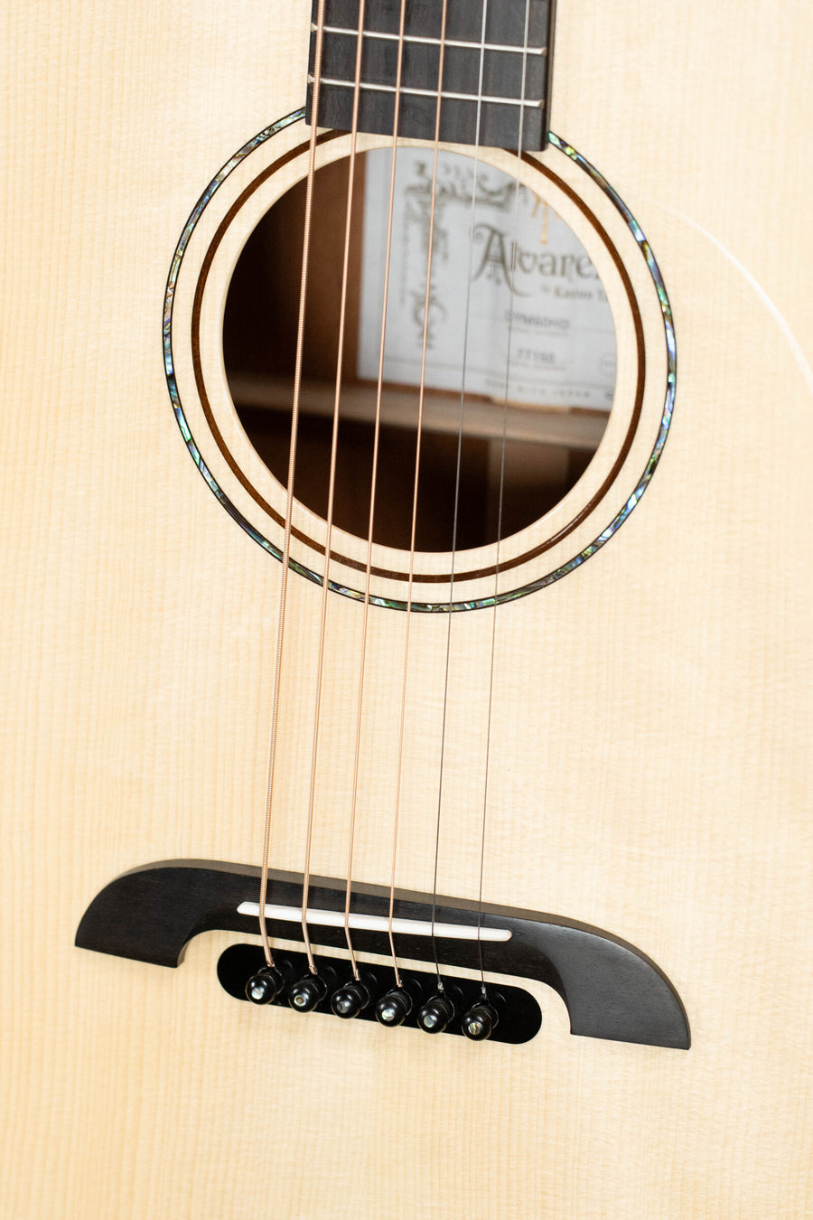 Close-up of dreadnought acoustic guitar soundhole and bridge with six strings on natural wood top. - Alvarez Yairi Honduran Series DYM60HD Adirondack/Vintage Honduran Mahogany Dreadnought Acoustic Guitar #7150 - Default Title