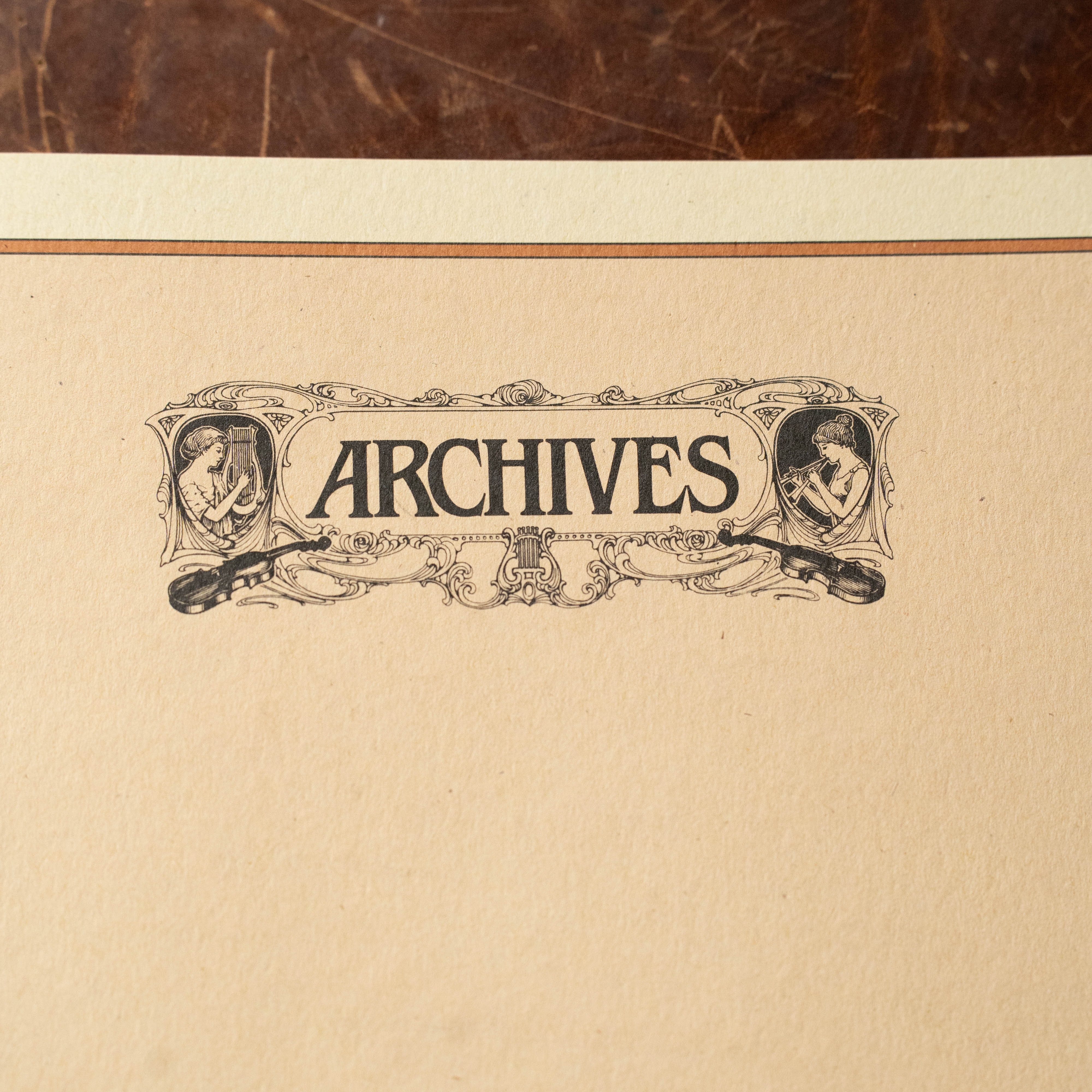 The Acoustic Shoppe's Archives 48 pg 10 Stave book features vintage-style paper with "ARCHIVES" in ornate lettering and detailed illustrations, reminiscent of a classic 9x12 music manuscript.