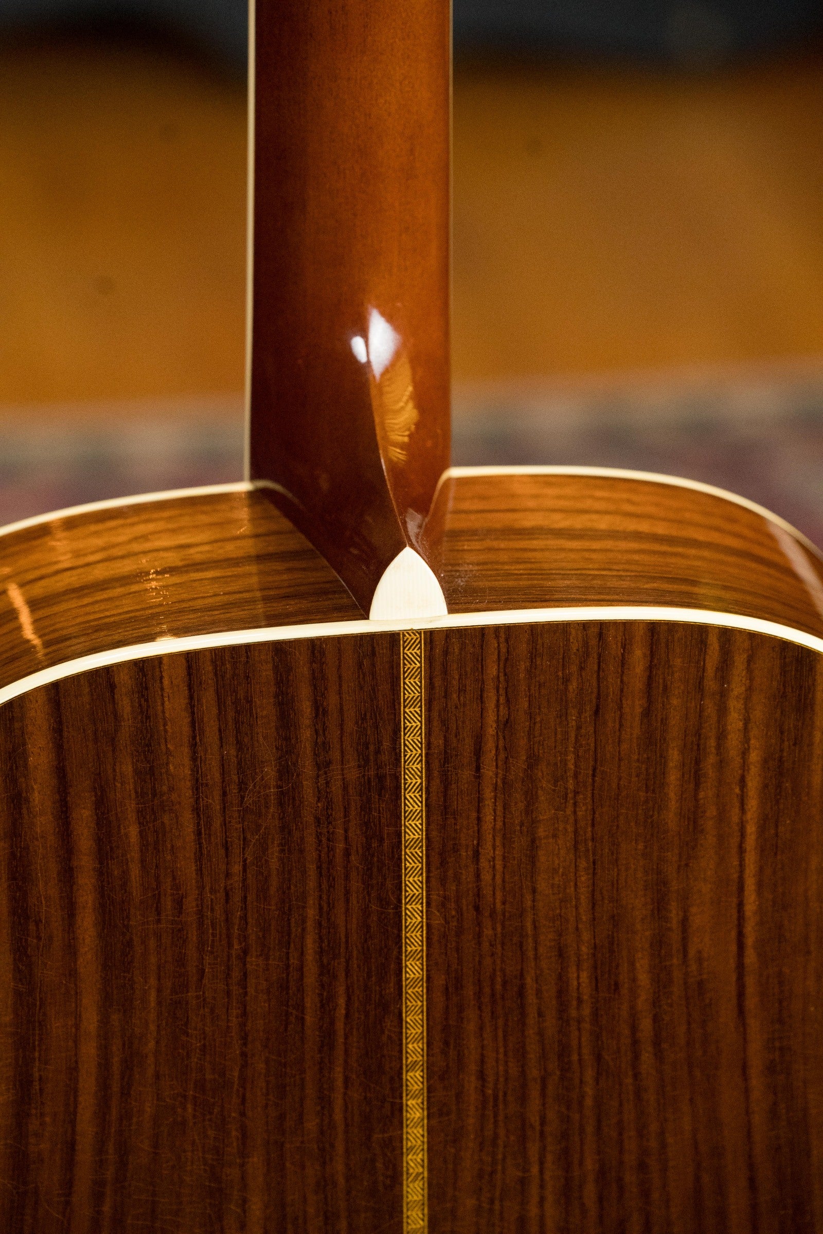 Close-up of the neck joint on the Atkin Guitars White Rice Baked Sitka/Rosewood Dreadnought Acoustic Guitar #3497, showing Indian rosewood grain, decorative center inlay, and glossy finish.