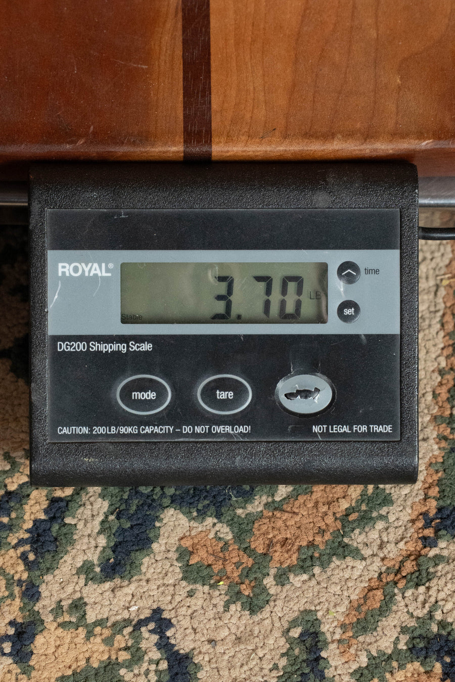 A digital shipping scale on a patterned carpet shows 3.70 pounds—the weight of the Atkin 19 Kingfisher Sitka/Maple Dreadnought Acoustic Guitar #3892 by Atkin Guitars. The ROYAL DG200 Scale includes mode, tare, and set buttons.