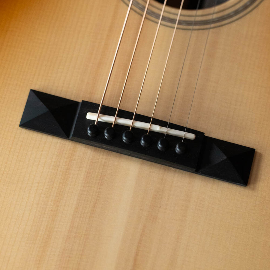 Close-up of black bridge and white saddle on tea-burst acoustic guitar body with six steel strings. - Bedell Special Edition Adirondack/Rosewood 14 Fret Tea-Burst Parlor Acoustic Guitar w/Wide Nut #4018 - Default Title