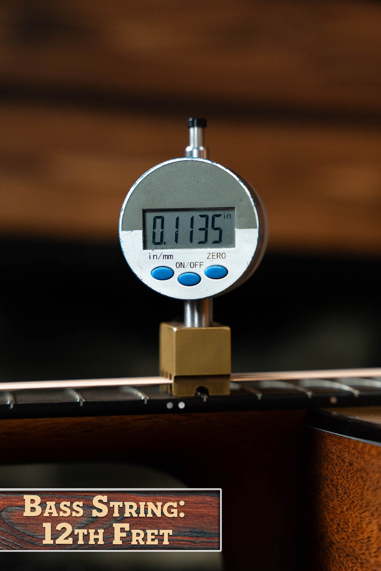 A digital gauge shows 0.1135 inches measuring the bass string height at the 12th fret on a Boucher BG-42T-G Bluegrass Goose Series Torrefied Dreadnought Acoustic Guitar by Boucher Guitars. Label: Bass String: 12th Fret.