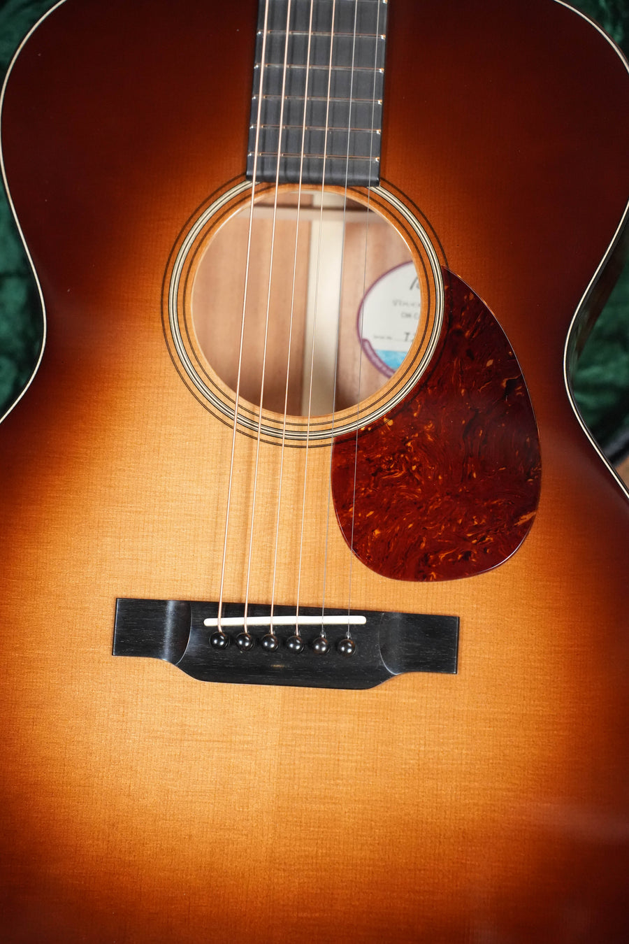 Close-up of the Bourgeois Country Boy Touchstone Series Sitka/Mahogany Sunburst Orchestra Model Acoustic Guitar #0252, highlighting its body, sound hole, strings, bridge, and pickguard—ideal for fingerstyle enthusiasts.