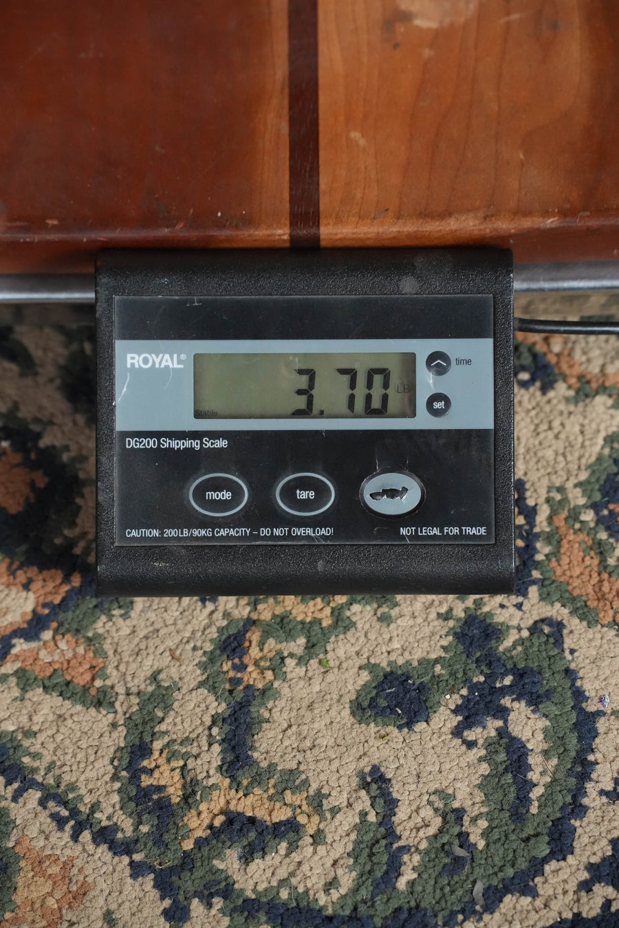 A digital shipping scale on patterned carpet shows 3.70 pounds—the ideal lightweight build for the Bourgeois The Standard LDBS/TS Touchstone Series Torrefied Sitka/Mahogany OO Sunburst Acoustic Guitar #1252.