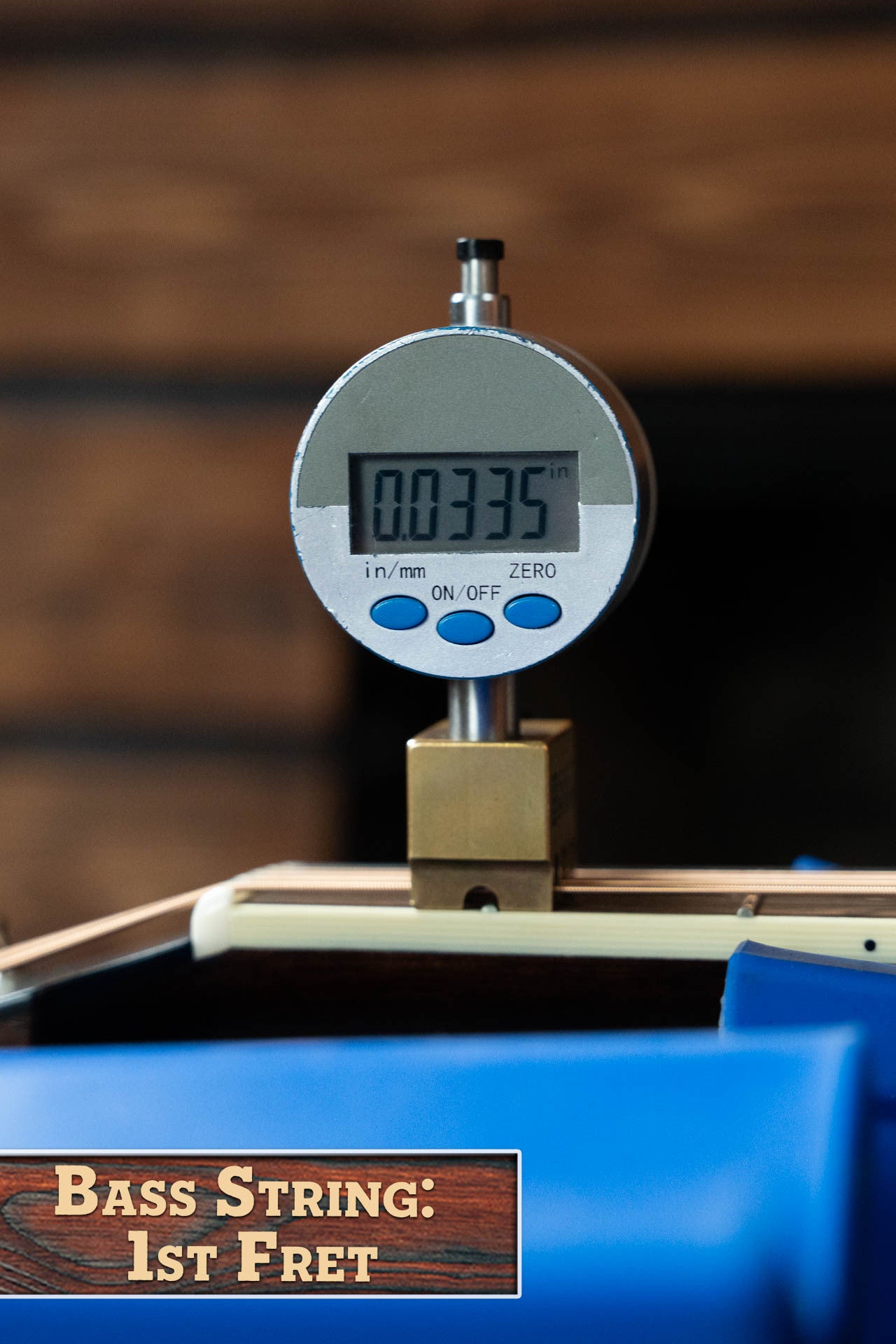 A digital gauge shows 0.0335 inches for the string height at the 1st fret of a Bourgeois Blues PSBB-LDBO-S Satin Professional Series All Mahogany OO Acoustic Guitar #1197. A "Bass String: 1st Fret" label appears, with blurred wood in the background.