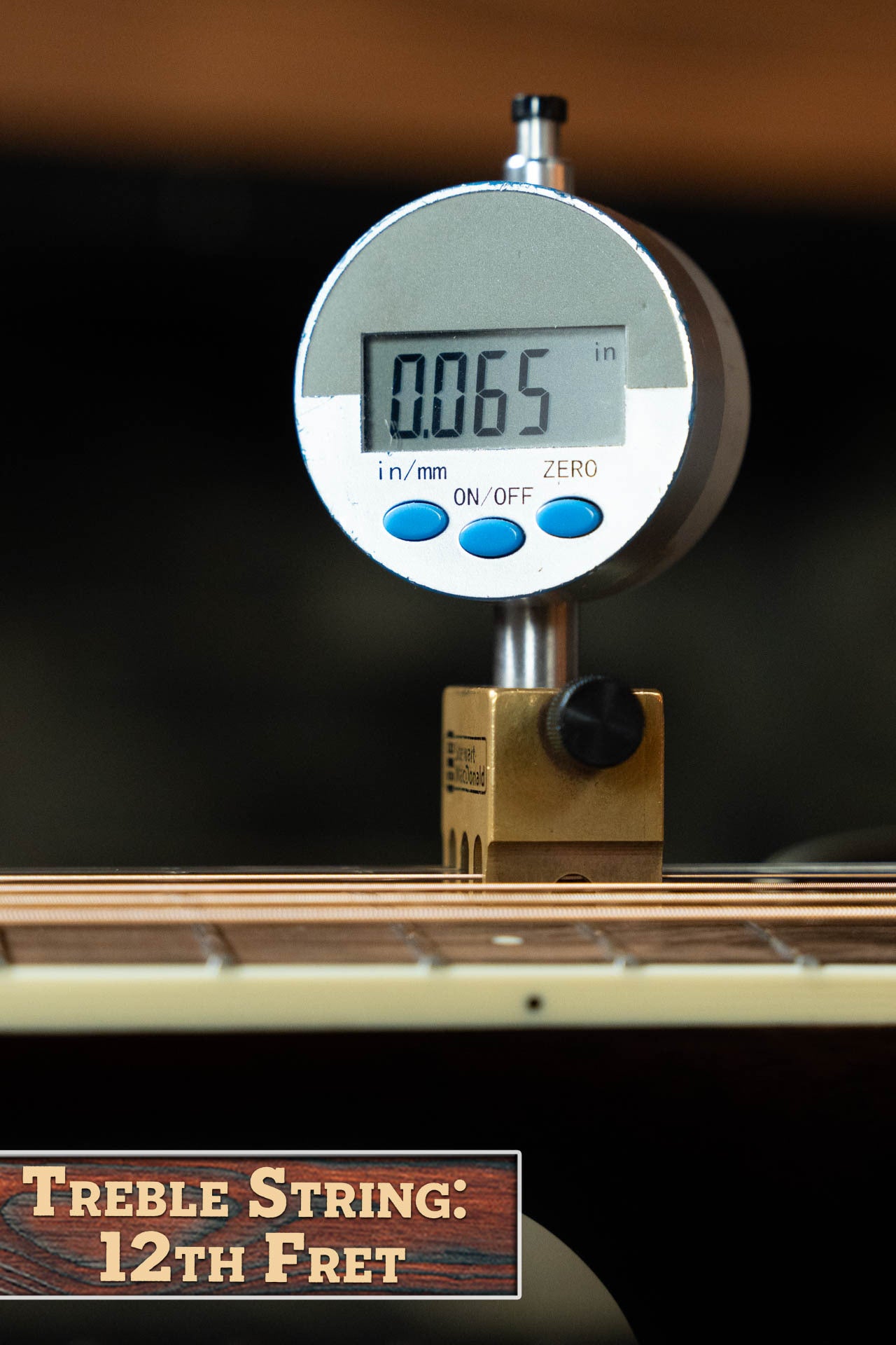 A digital gauge reads 0.065 inches at the 12th fret treble string of the Bourgeois Blues PSBB-LDBO-S Satin Professional Series All Mahogany OO Acoustic Guitar #1197. Label: Treble String, 12th Fret.