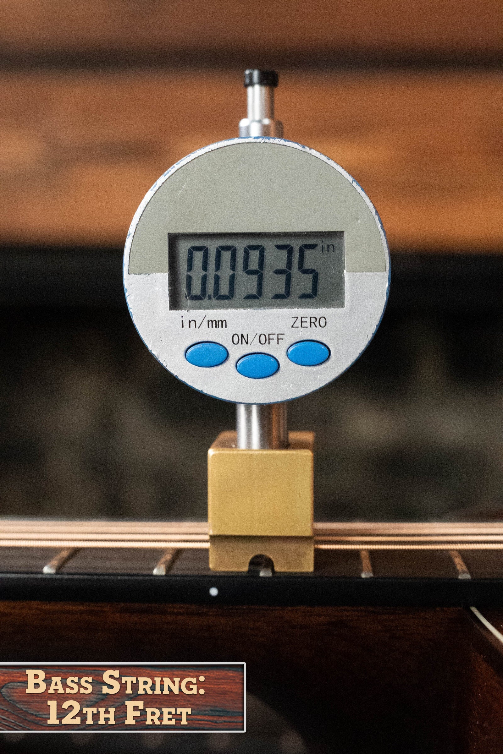 A digital gauge reads 0.0935 inches for the string height at the 12th fret of the Bourgeois Professional Series Hog Top All Mahogany OM Acoustic Guitar #1208. The label below states: Bass String: 12th Fret.