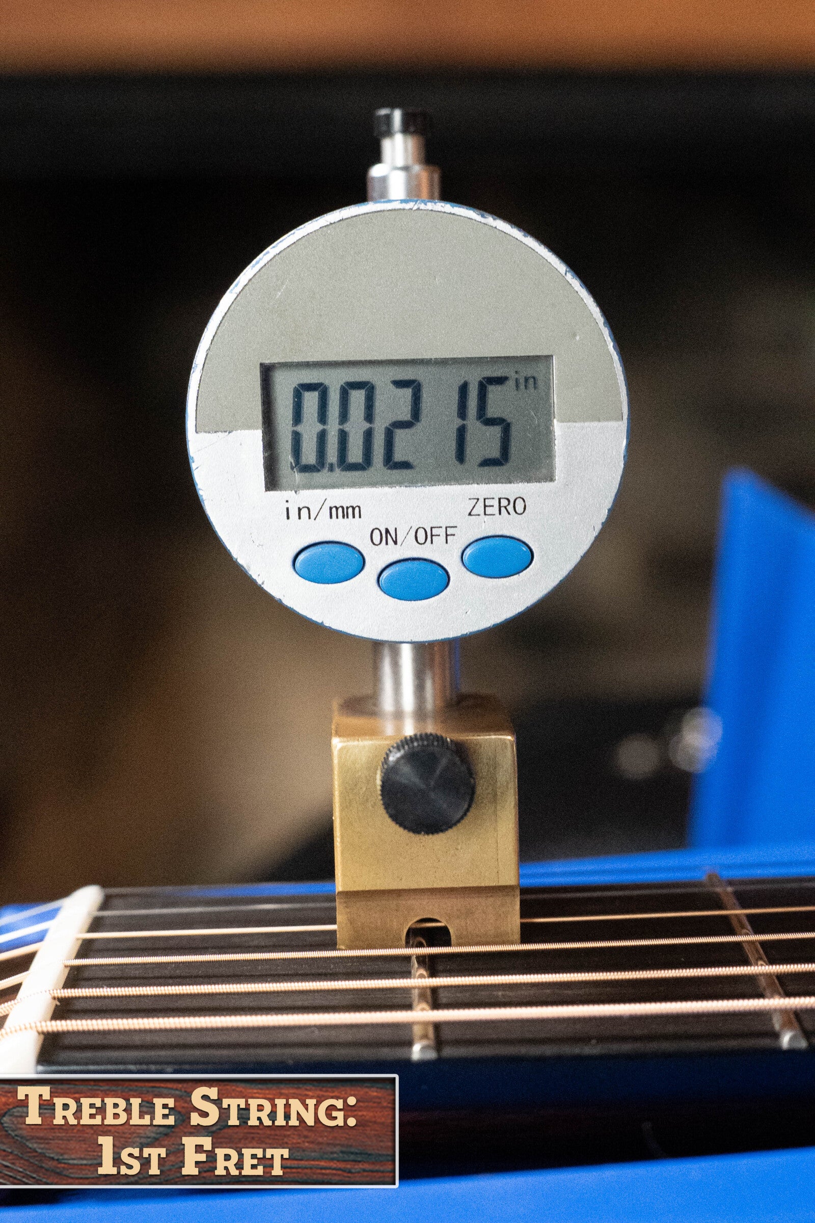 A digital gauge measures 0.0215" above the first fret of a Bourgeois Professional Series Hog Top All Mahogany OM Acoustic Guitar #1208 treble string. Bold text at bottom left reads TREBLE STRING: 1ST FRET.