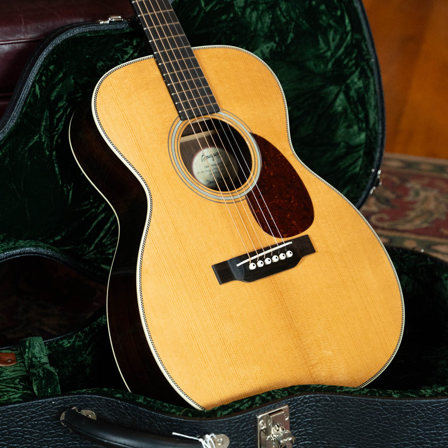 A Bourgeois Heirloom Series T-Bar Banjo Tuner Vintage HSV-OM Aged Tone Adirondack/Brazilian Rosewood Orchestra Model Acoustic Guitar #1098 rests in an open, green velvet-lined hard case on a wooden floor.