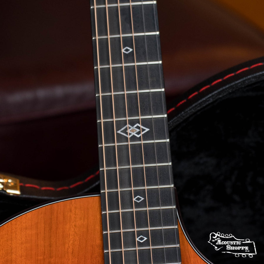 Close-up of a Breedlove Limited Oregon Series All Myrtlewood Thinline Hot Rod Concert CE Guitar’s fretboard with diamond inlays. In the background, see a partially open case with red stitching, Acoustic Shoppe logo, and LR Baggs pickup (#9881).