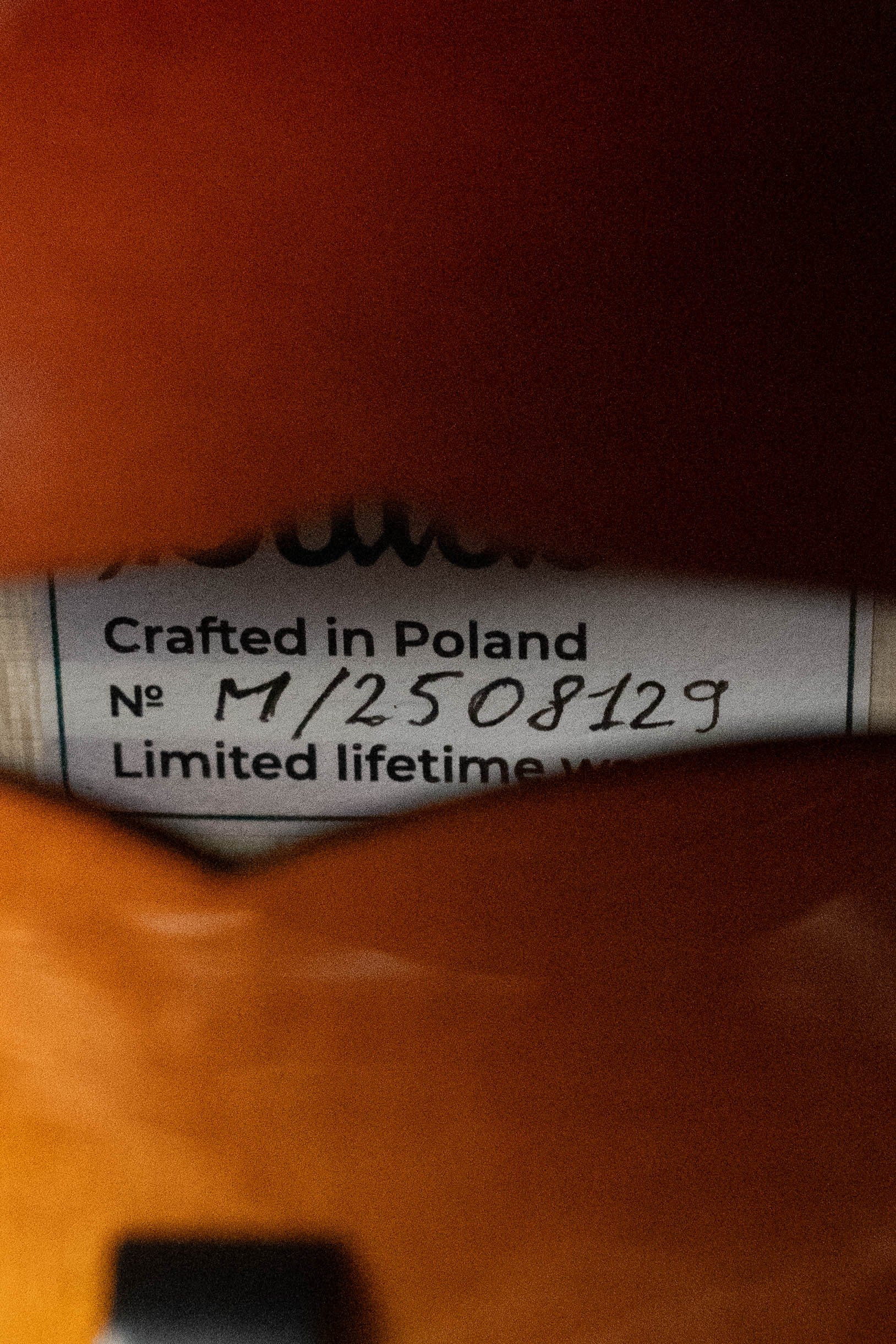 A close-up through the f-hole of the Bulas Carpathian Spruce/Curly Maple Cremona Sunburst A-Style Mandolin #8129 shows a label reading Crafted in Poland, partially obscured by the instrument's Carpathian spruce body.