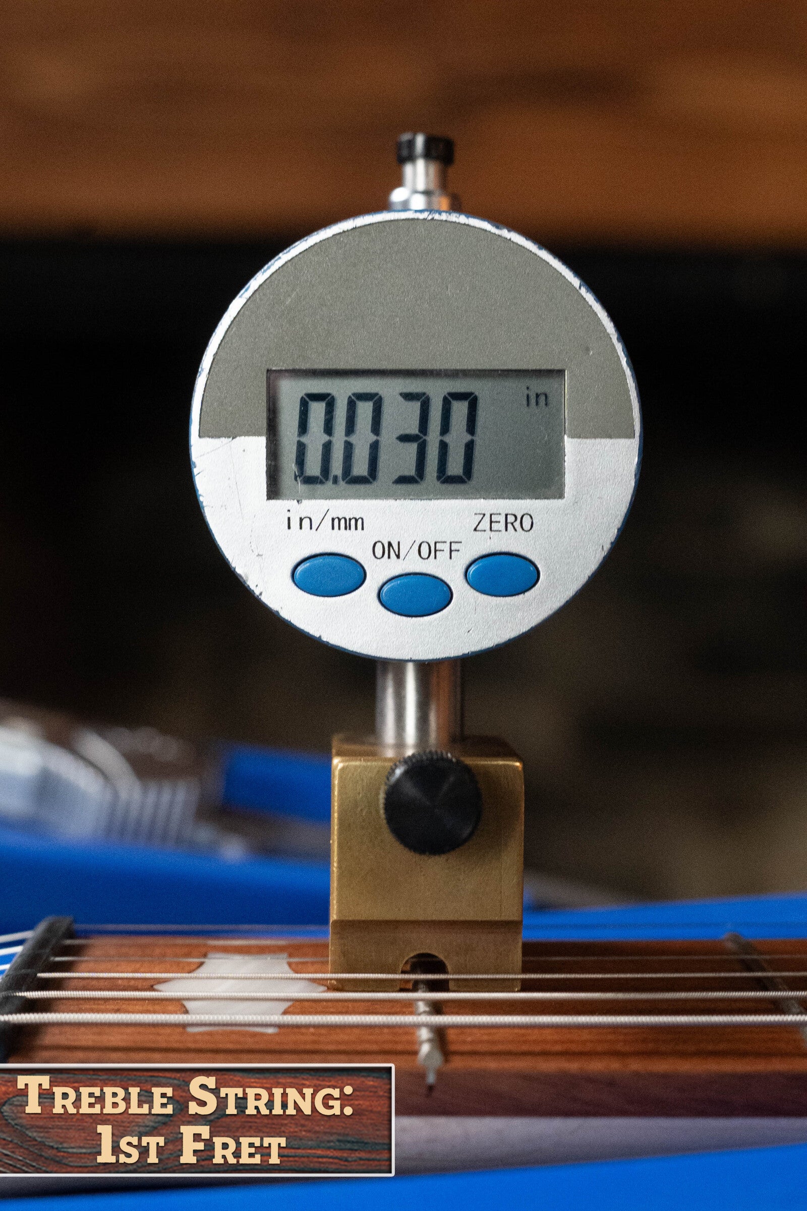 A Deering Goodtime Six-R 6-String Resonator Banjo w/Kavanjo Pickup by Deering Banjos shows a digital caliper reading of 0.030 inches above the treble string at the 1st fret, labeled: Treble String: 1st Fret.