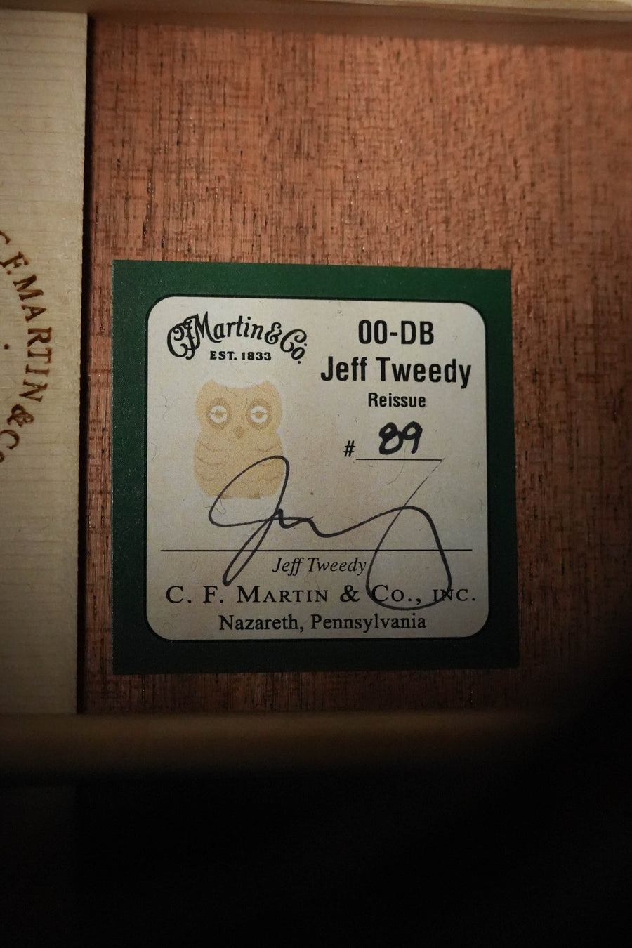 Inside the guitar is a label reading: Martin & Co. *Dread-Not Certified Used* 2025 OO-DB Jeff Tweedy All FSC Mahogany #9777, with Jeff Tweedy’s signature, company info, and an owl illustration highlighting this collaboration.