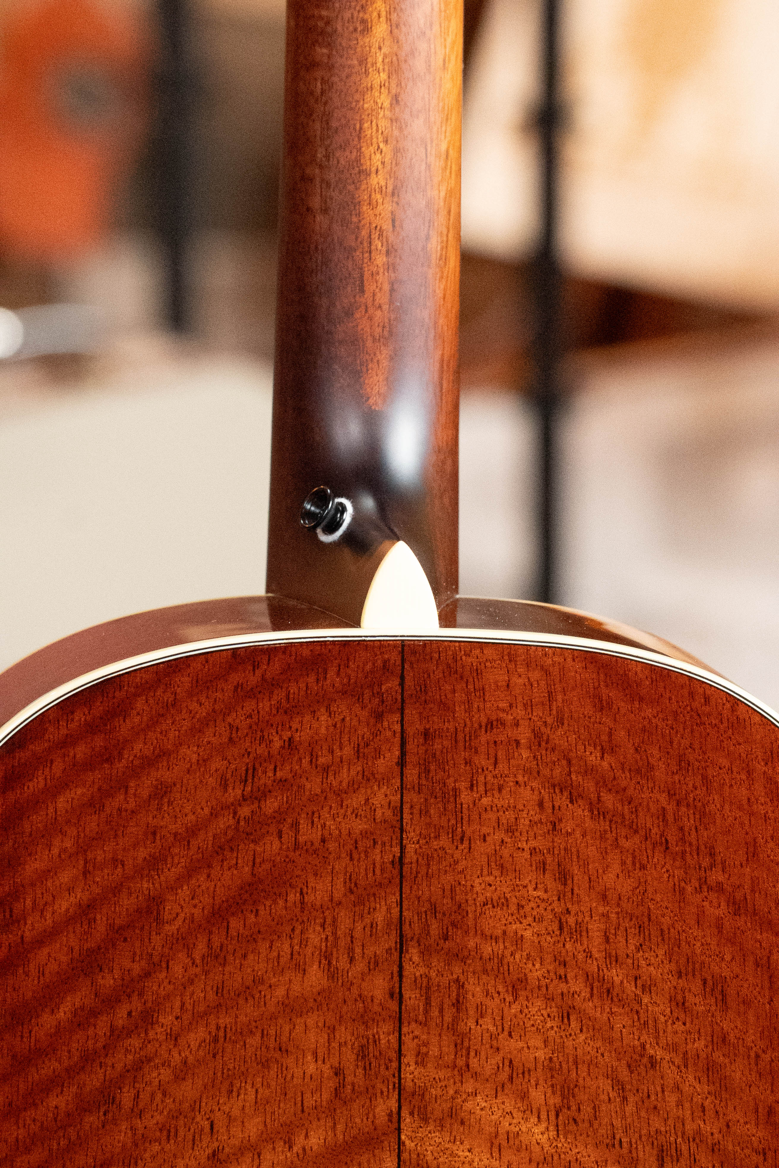 Close-up of the neck joint on this *Dread-Not Certified Used* Eastman E6-LGSS-TC-SB Slope Shoulder Sunburst Acoustic Guitar, highlighting mahogany back/sides, strap button, and fine craftsmanship by Eastman Guitars.