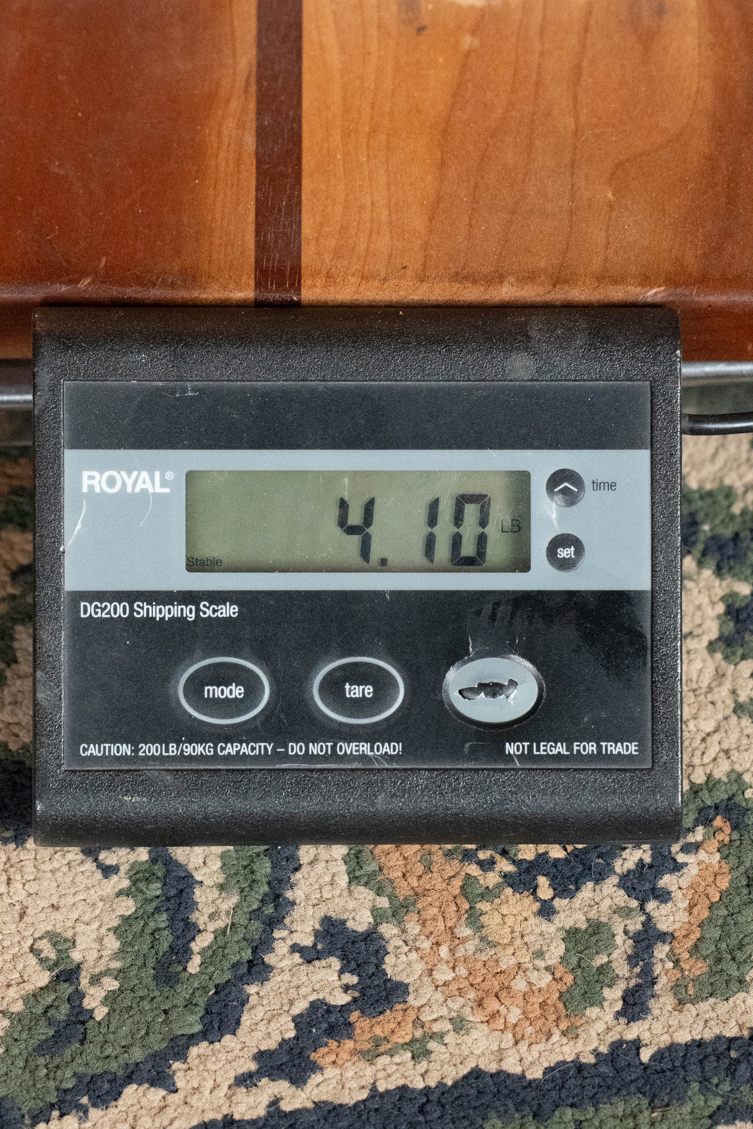 A digital shipping scale shows 4.10 lbs while weighing the *Dread-Not Certified Used* Eastman E6-LGSS-TC-SB Thermo-Cured Sitka/Mahogany LG-Style Slope Shoulder Sunburst Acoustic Guitar #9323 by Eastman Guitars.