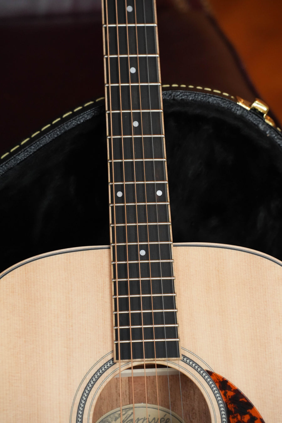 Close-up of a *Dread-Not Certified Used* Larrivée D-03 Sitka/Mahogany Dreadnought Acoustic Guitar #3382’s fretboard and body, resting in an open black case with brown leather edge; features a light solid Sitka spruce top and visible strings.