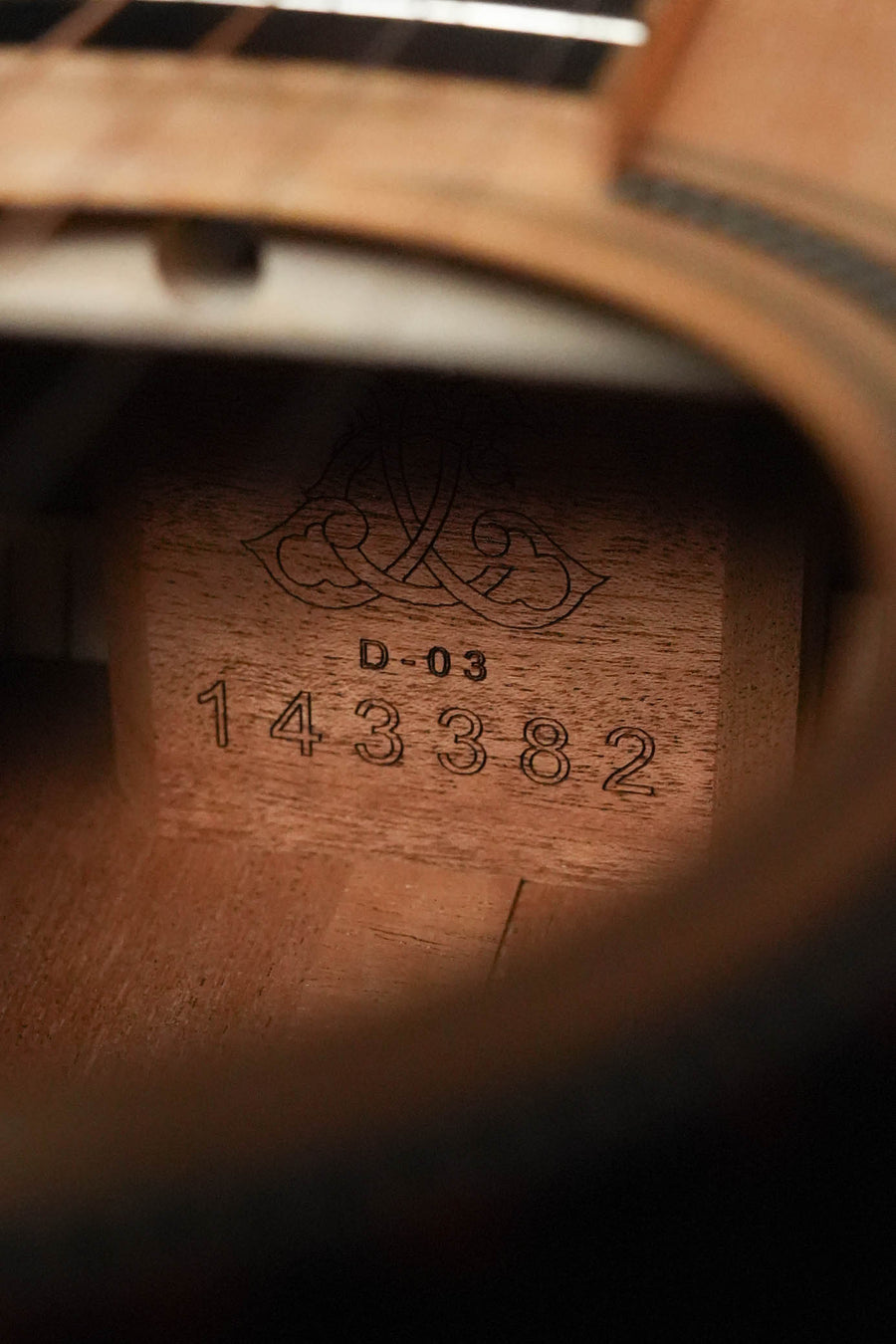 Close-up view through the sound hole of a Larrivée *Dread-Not Certified Used* D-03 Sitka/Mahogany dreadnought acoustic guitar (#3382), showing the ornate interior label on the solid Sitka spruce top.