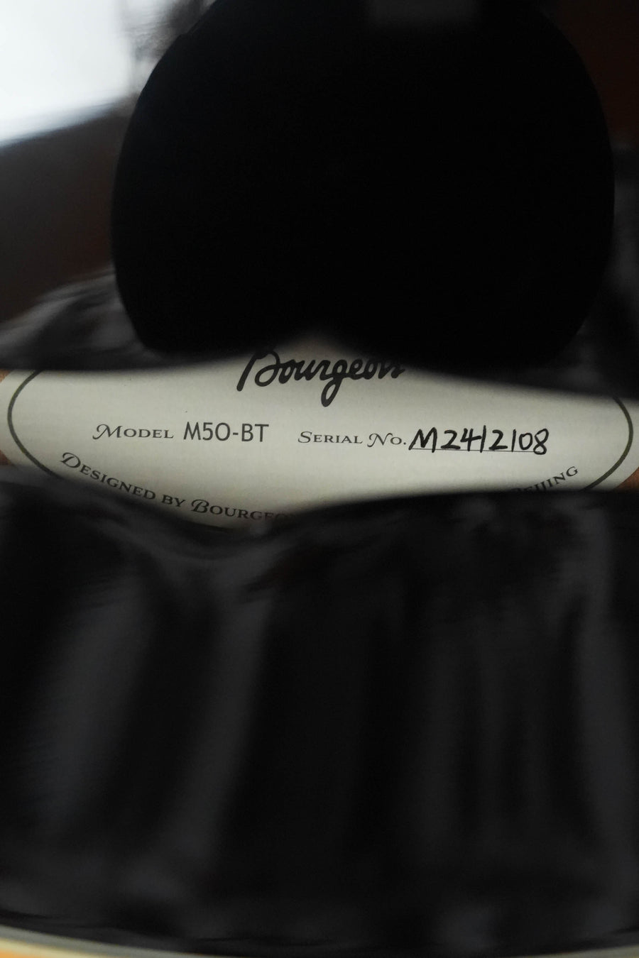 Close-up of the *Dread-Not Certified* Bourgeois M5-O-BT Black Octave Mandolin #2108 label, highlighting its Aged Tone Adirondack top and European Curly Maple craftsmanship.