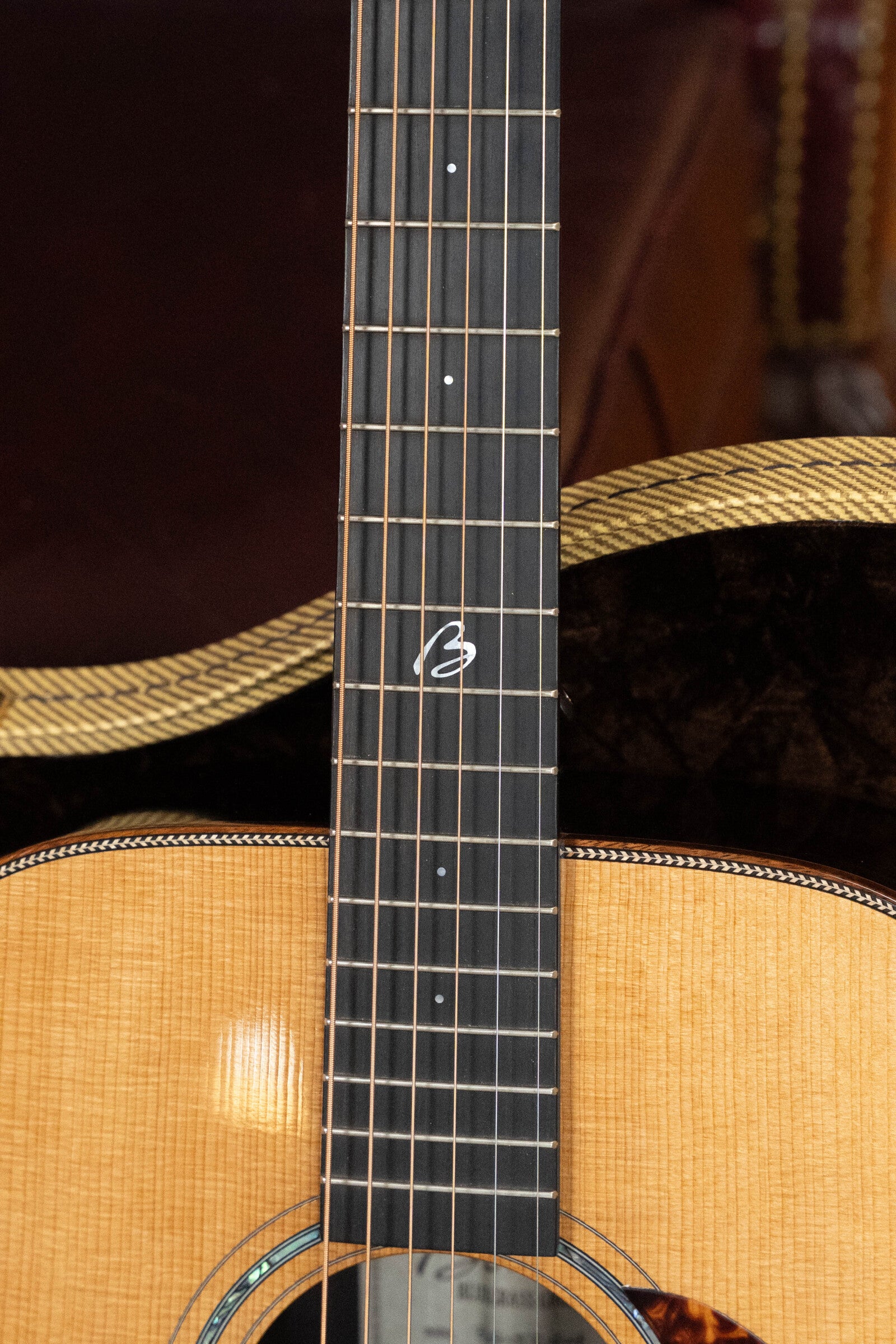 Close-up of the *Dread-Not Certified Used* Boucher BG-52-GM Bluegrass Goose Series dreadnought by Boucher Guitars, showing its torrefied Adirondack Red Spruce top, unique 12th fret inlay, and light wood finish; case partly visible.