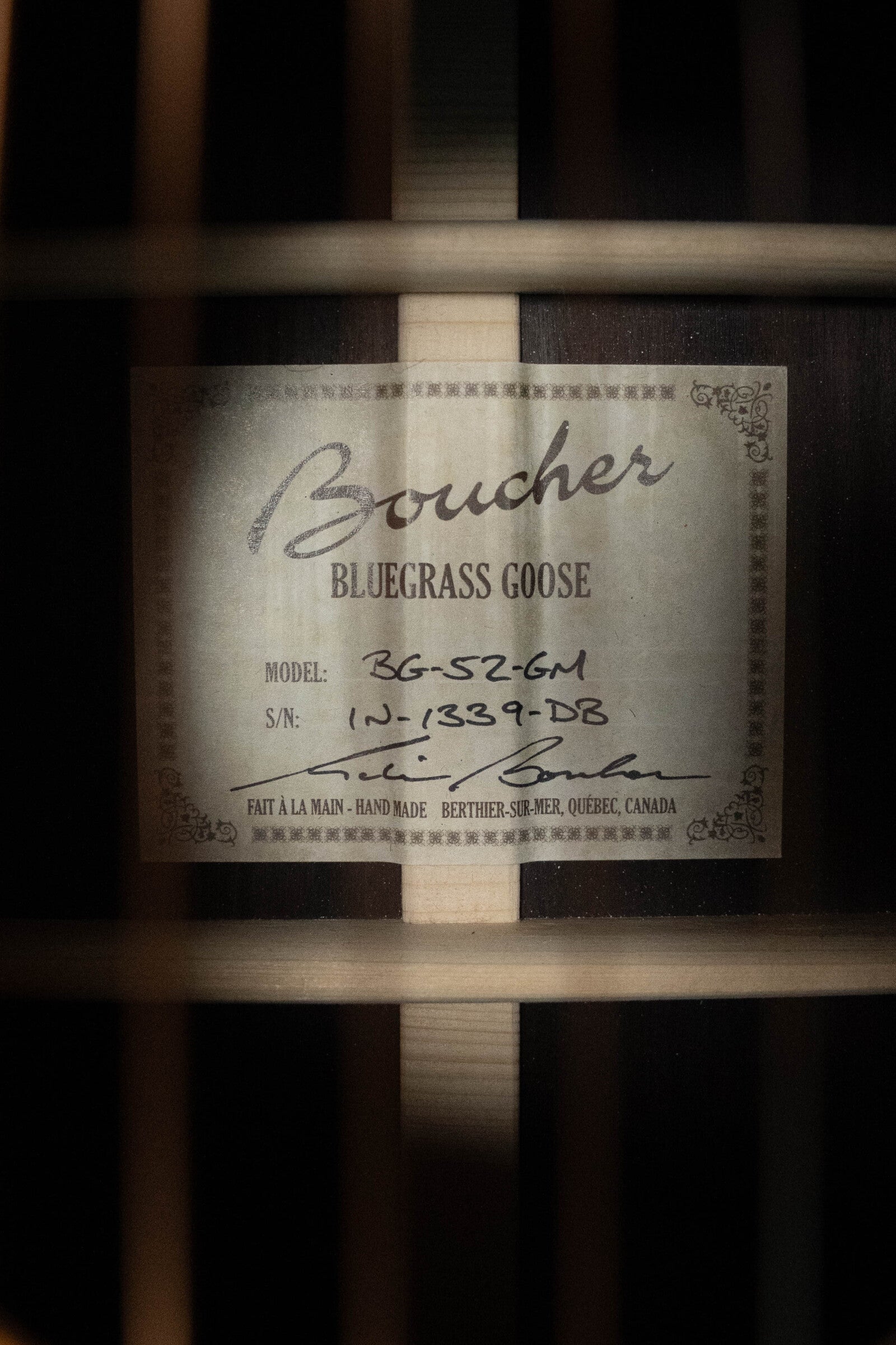 Close-up of a Boucher Guitars label inside the *Dread-Not Certified Used* BG-52-GM Bluegrass Goose #1339, dreadnought with master grade torrefied Adirondack Red Spruce top and East Indian Rosewood back/sides. Handmade in Quebec, Canada.