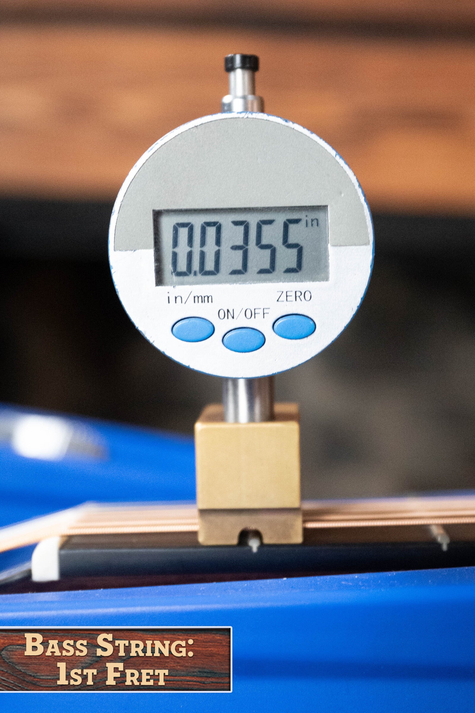 A digital gauge shows 0.0355 inches above the first fret of a bass guitar, labeled Bass String: 1st Fret, mirroring the precise setup found on Boucher Guitars’ Dread-Not Certified Used BG-52-GM Bluegrass Goose Series Dreadnought #1339.