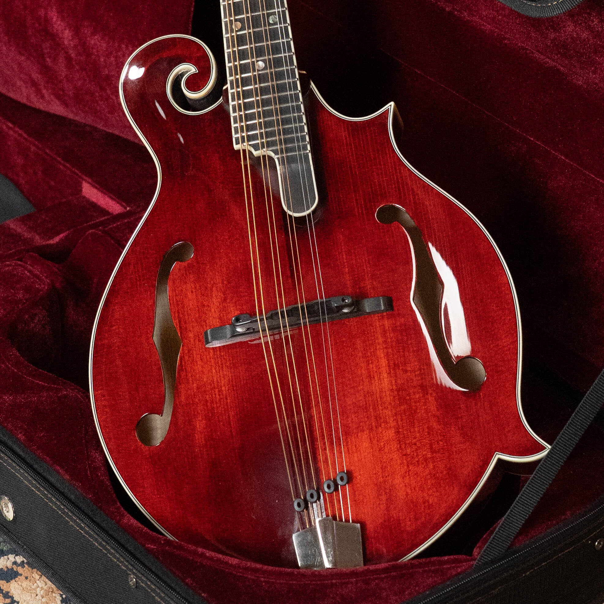 The *Dread-Not Certified Used* Eastman MDA815 F-Style Mandola Classic Finish #4978 by Eastman Guitars, with graceful curves and f-holes, a solid spruce top, comes nestled in a dark red velvet-lined case.