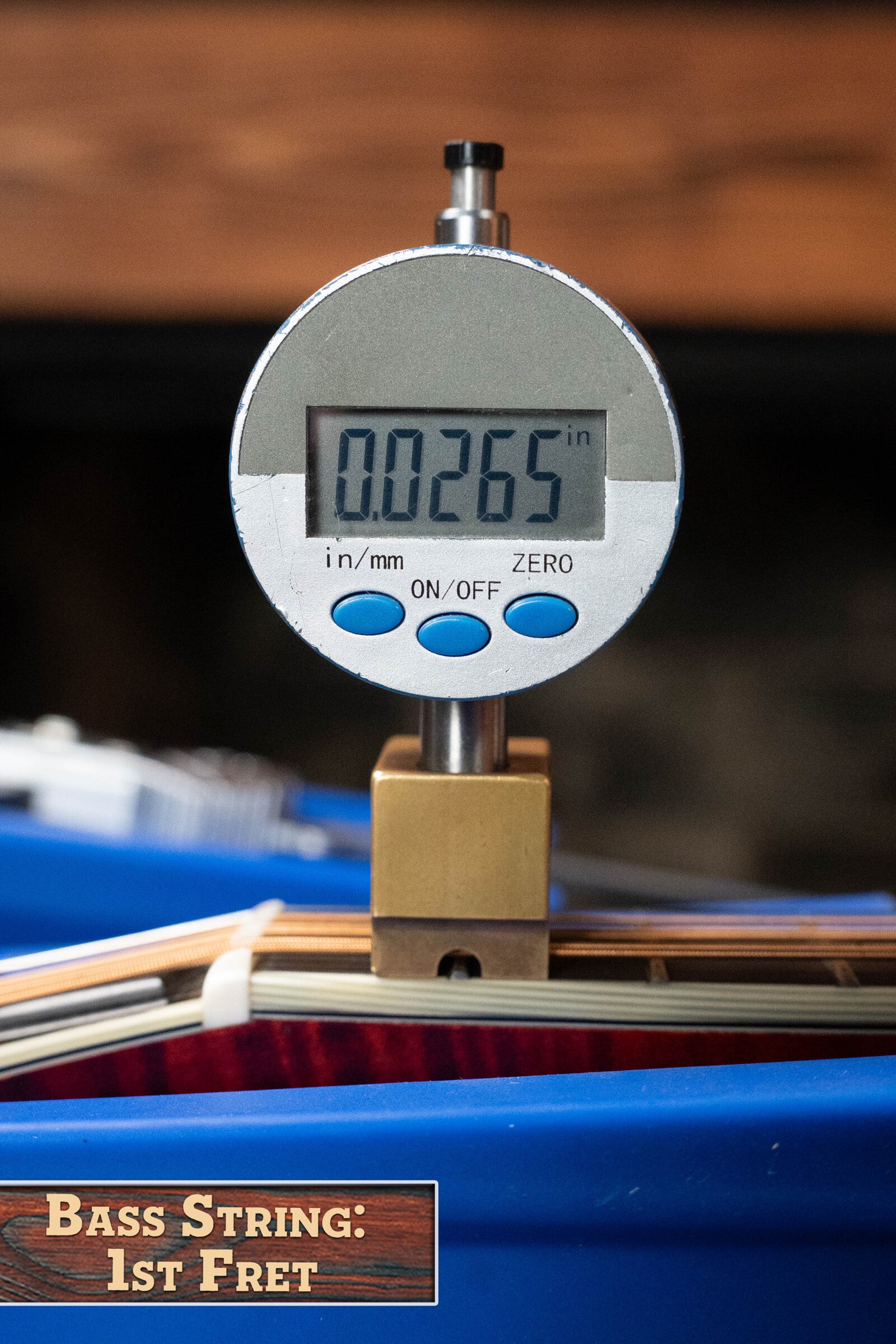 A digital gauge reads 0.0265 inches measuring the string height at the 1st fret, labeled "Bass String: 1st Fret," beside a *Dread-Not Certified Used* Eastman Guitars MDA815 F-Style Mandola Classic Finish #4978 with solid spruce top.