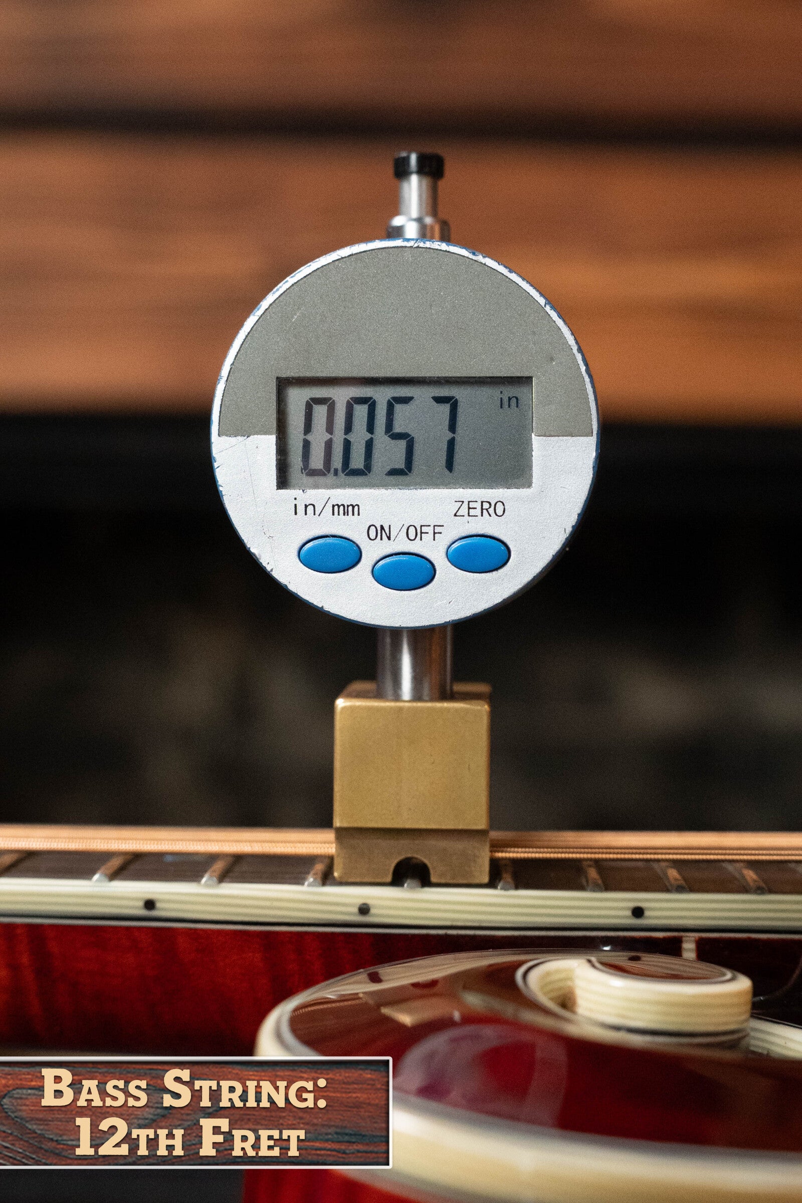 A digital caliper measures string height at the 12th fret of an *Eastman Guitars Dread-Not Certified Used* MDA815 F-Style Mandola Classic Finish #4978, displaying 0.057 inches. Label reads: Mandola String, 12th Fret; fretboard and spruce top are partly visible.