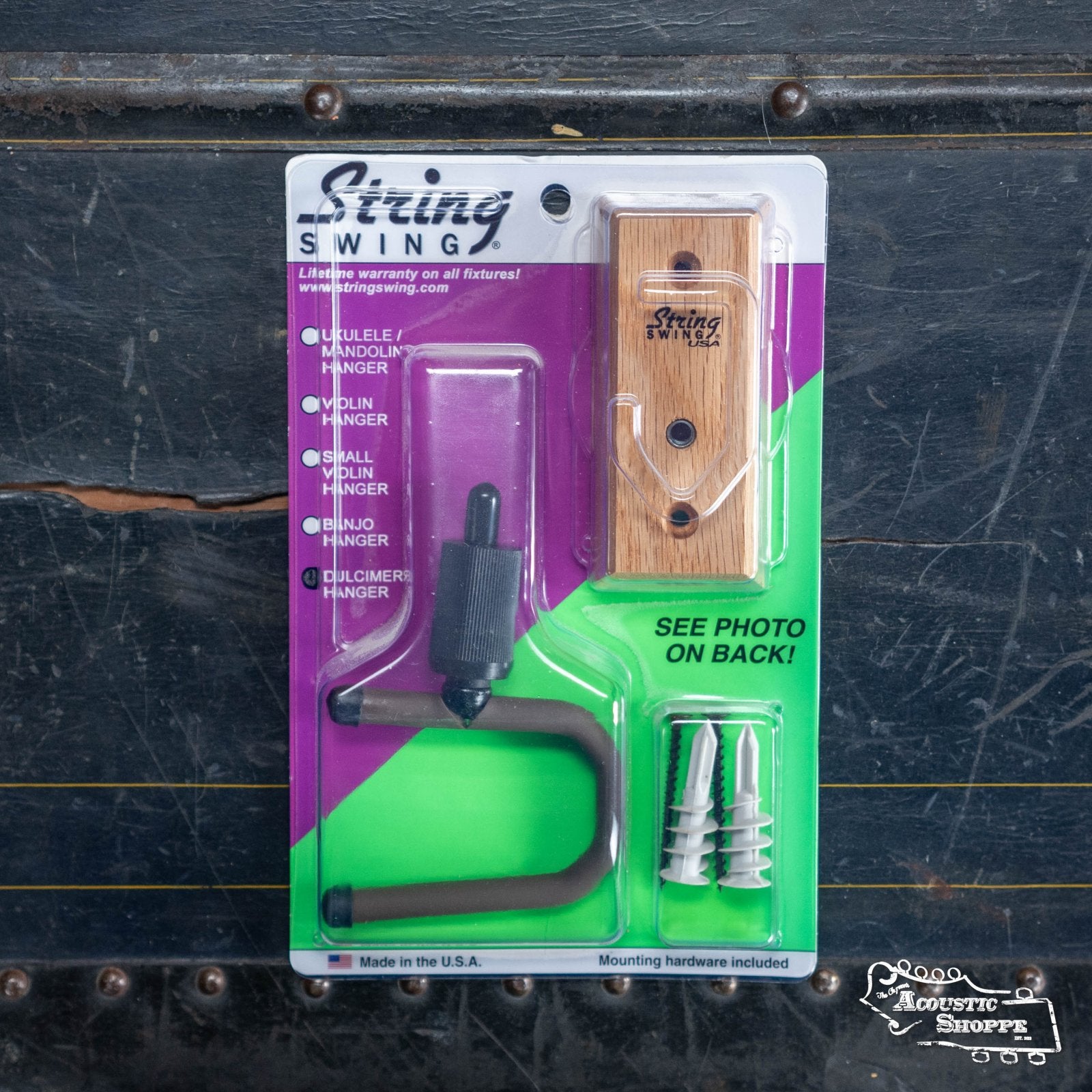 The String Swing Home & Studio Dulcimer wall mount hanger by String Swing is shown packaged with mounting hardware and instructions on a dark, textured surface; ideal for dulcimers and other small instruments.