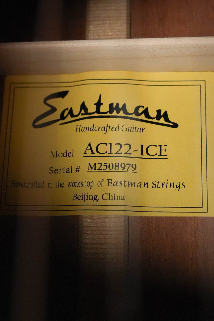 Yellow label inside this guitar reads: Eastman AC122-1CE Sitka/Sapele Natural Grand Auditorium Cutaway w/Fishman Pickup #8979. Made by Eastman Guitars, Beijing, China.