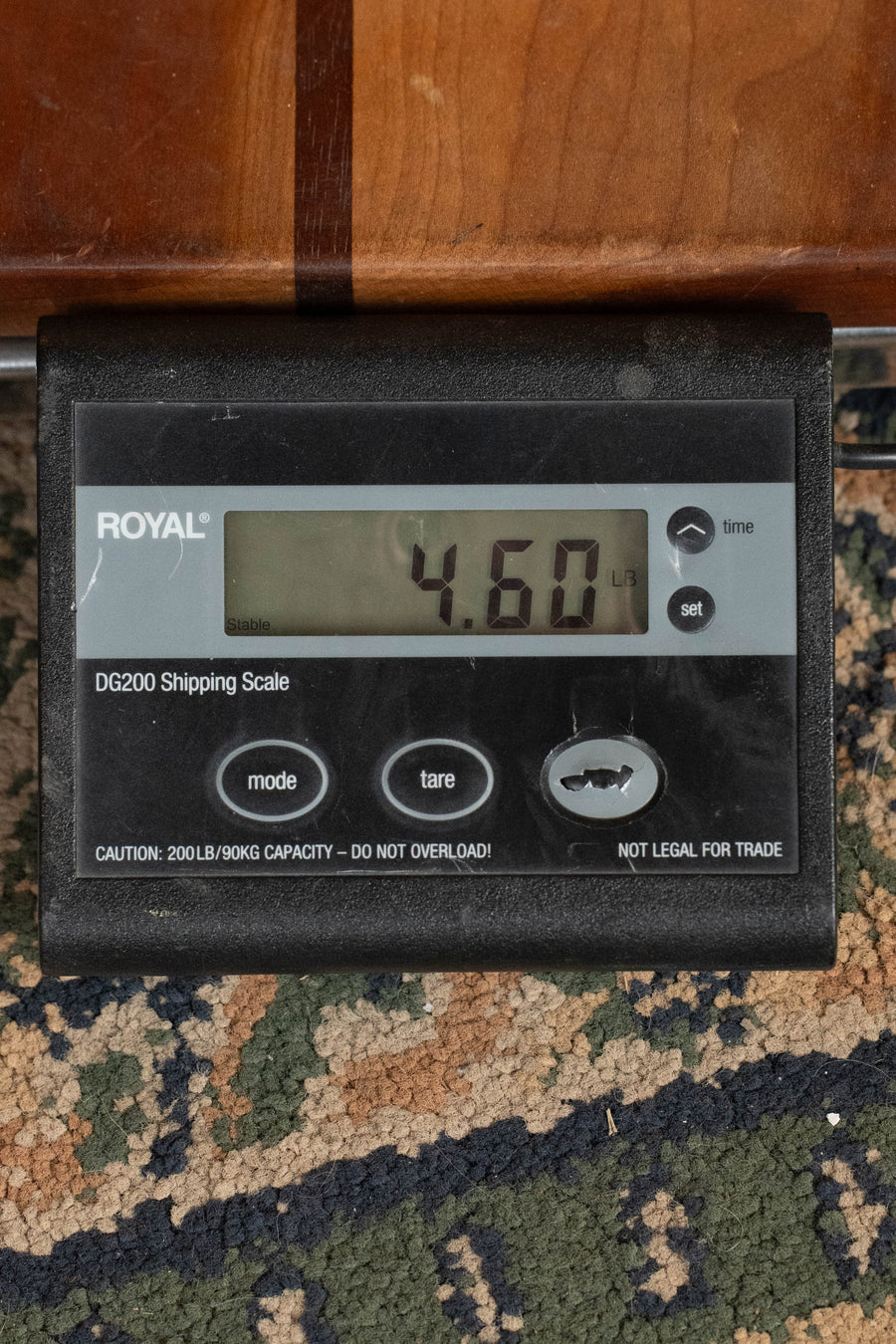 A digital shipping scale displays 4.60 pounds as the ROYAL DG200 sits on a patterned carpet by a wooden surface, ready to weigh items like the Eastman Guitars E10D-TC Thermo-Cured Adirondack/Mahogany Dreadnought Acoustic Guitar #7309.
