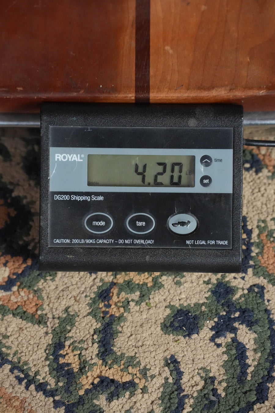 A digital shipping scale shows 4.20 pounds. The black ROYAL DG200 sits on patterned carpet, partially beneath an Eastman Guitars E10SS/V Adirondack/Mahogany Antique Classic Finish Slope Shoulder Dreadnought Acoustic Guitar #0366.