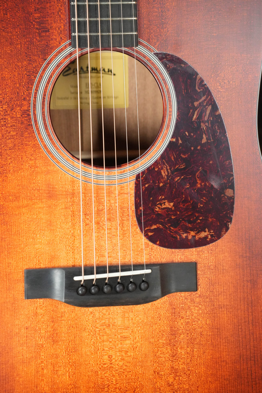 Close-up of the Eastman E1D-CLA Classic Finish Dreadnought Acoustic Guitar #9429 by Eastman Guitars, showing its solid Sitka spruce top, hand-scalloped X-bracing, tortoiseshell pickguard, label inside the sound hole, and rich wooden finish.