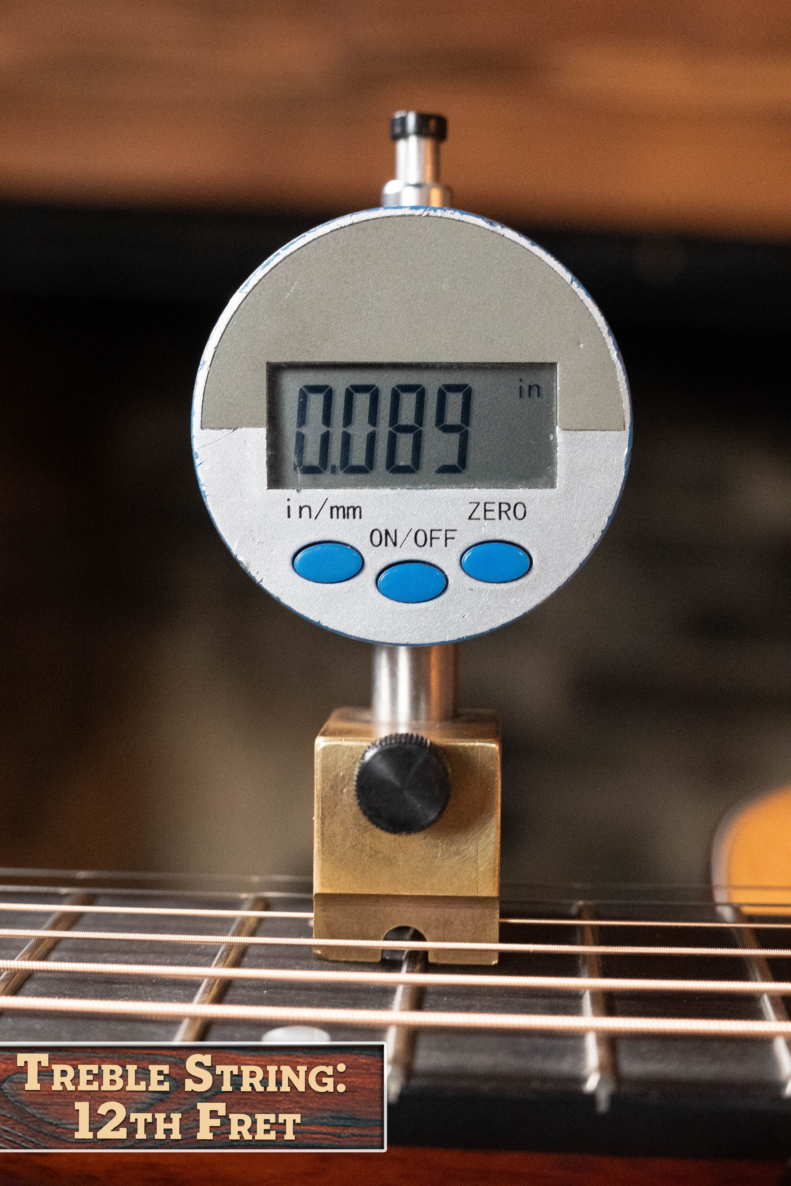 A digital gauge shows the string height at the 12th fret of an Eastman Guitars E1D-DLX Sitka/Sapele Dreadnought w/Fishman Pickup (#5656) as 0.089 inches, with a sign reading "Treble String: 12th Fret" in the lower left corner.