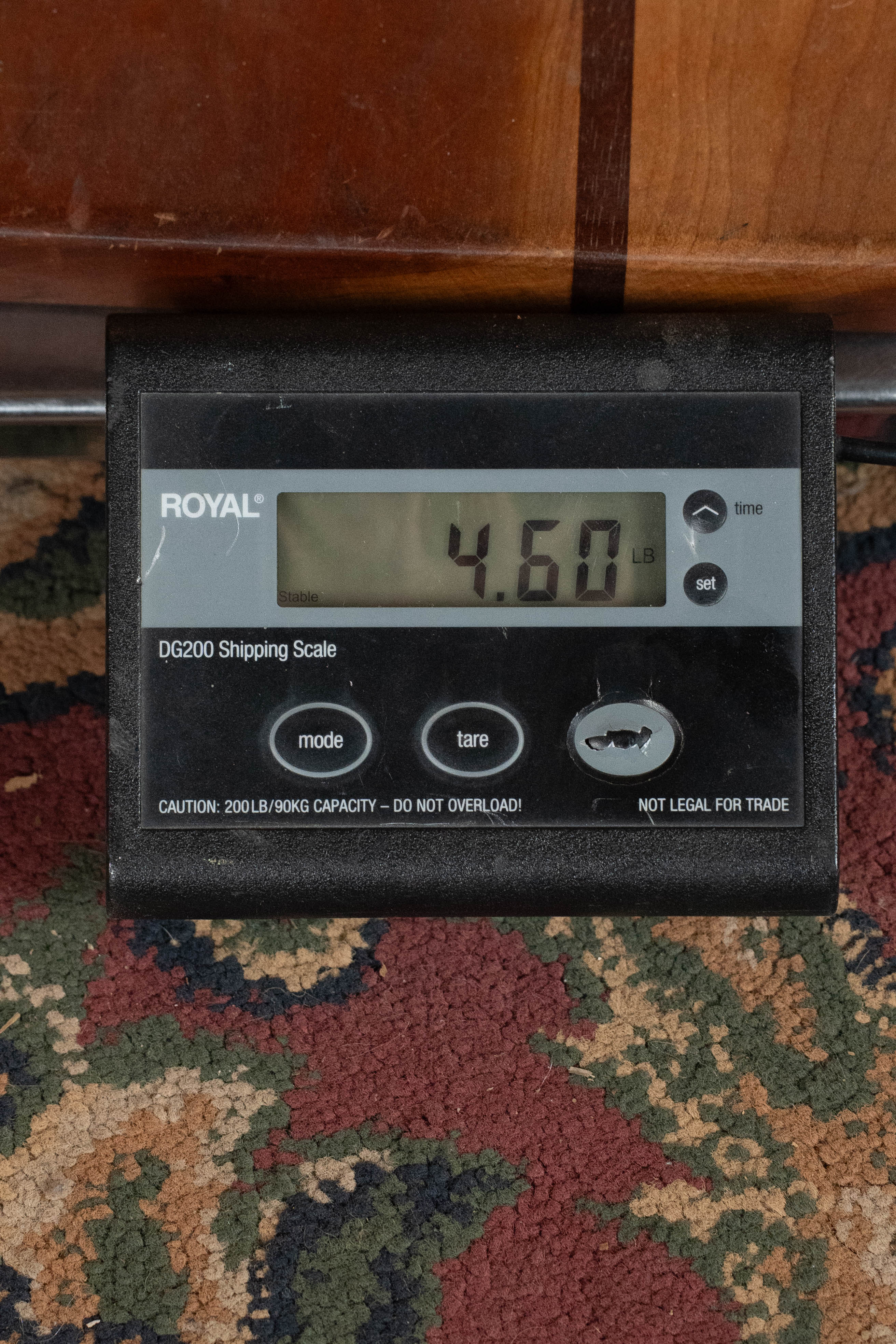 A ROYAL DG200 Shipping Scale shows a weight of 4.60 pounds on a patterned carpet, suitable for weighing items like the Eastman Guitars E1D-DLX Sitka/Sapele Dreadnought Guitar with Fishman Pickup #7721.