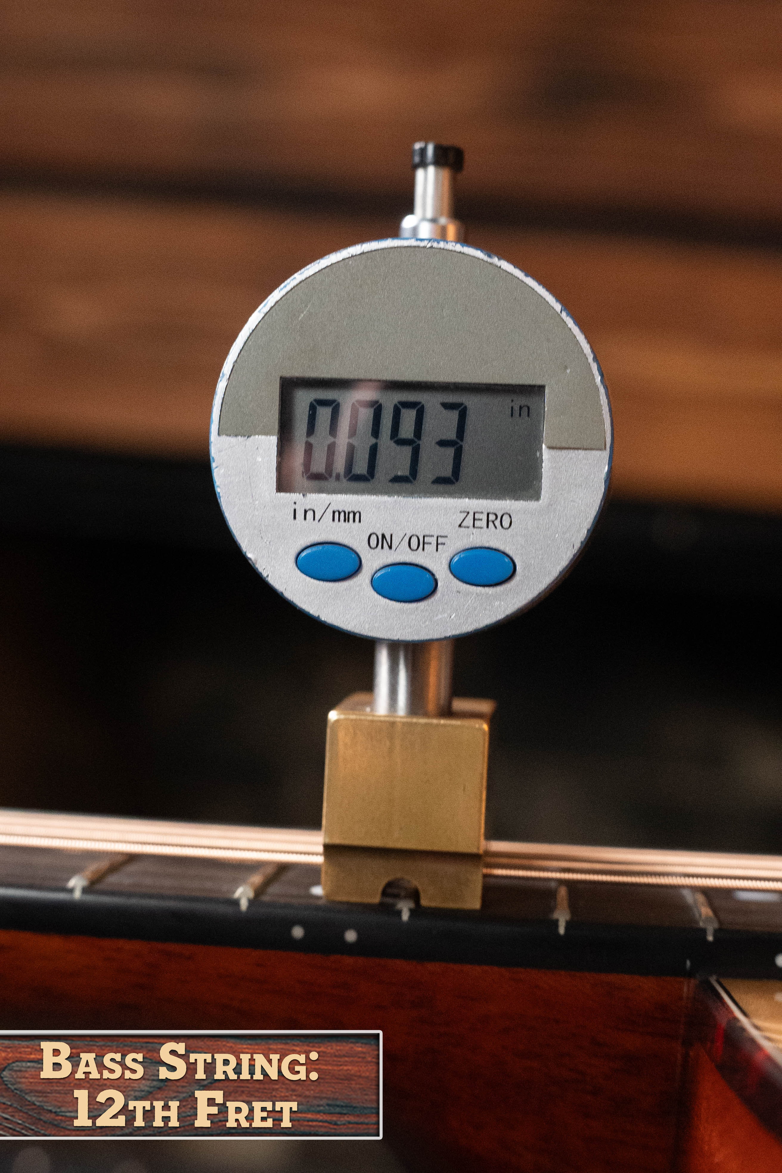 A digital caliper shows a bass guitar string at the 12th fret measures 0.093 inches. The label reads "Bass String: 12th Fret," echoing precise setups found on the Eastman Guitars E1D-DLX Sitka/Sapele Dreadnought w/Fishman Pickup (#7721).