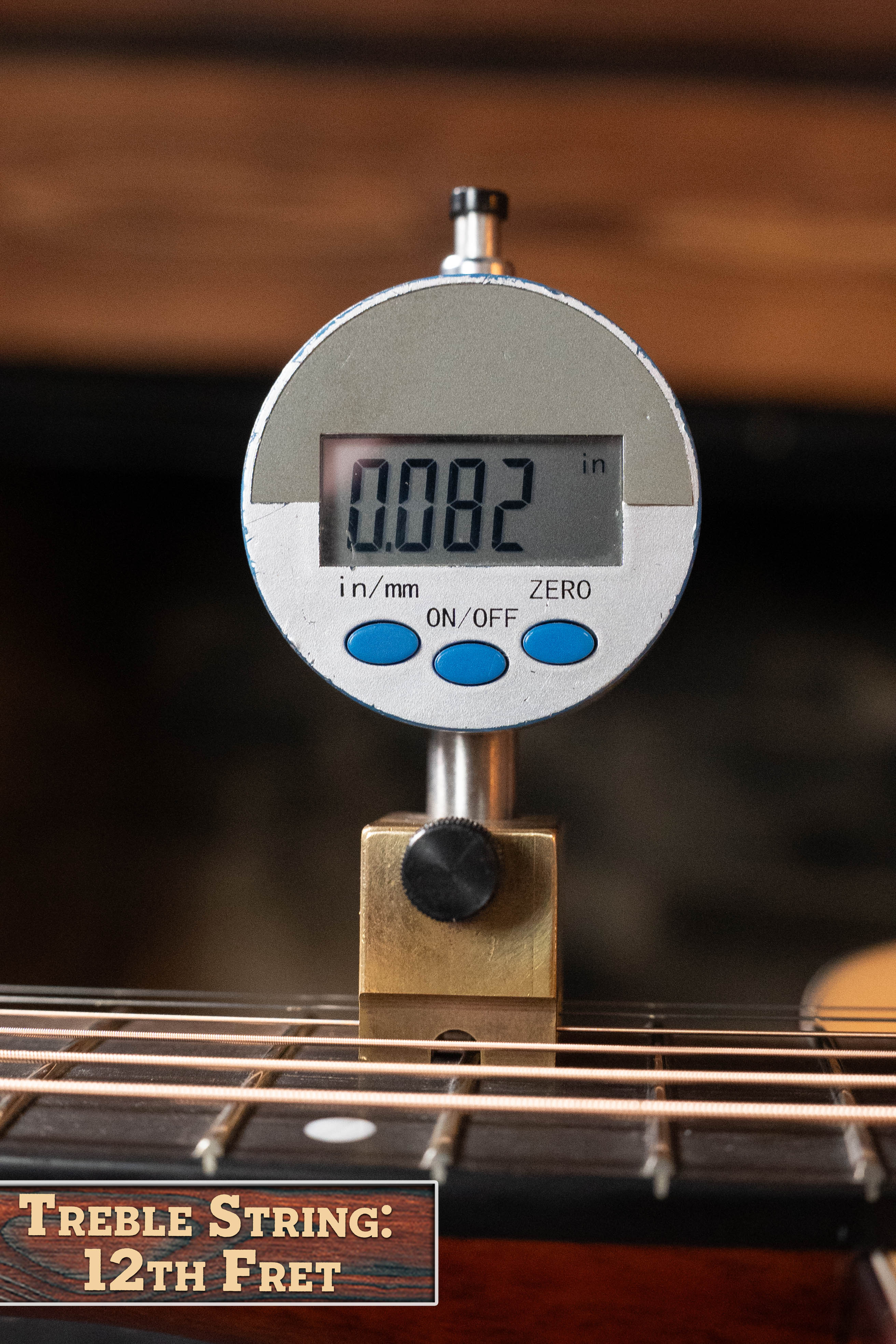 A digital gauge measures 0.082 inches above the 12th fret treble string on an Eastman Guitars E1D-DLX Sitka/Sapele Dreadnought w/Fishman Pickup #7721, highlighting the precise setup and solid Sitka spruce top.