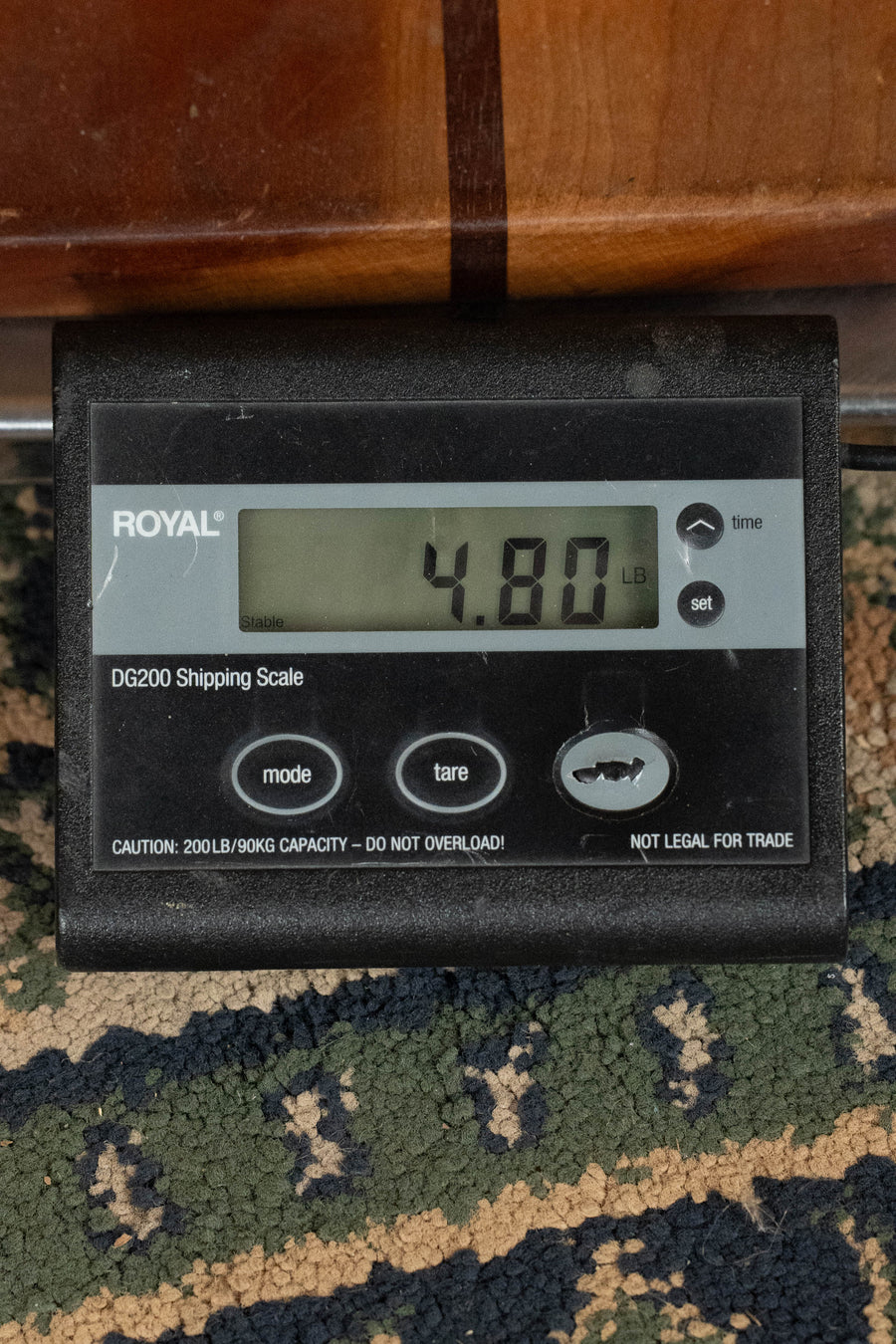 A ROYAL DG200 Shipping Scale on a patterned carpet displays 4.80 lbs—ideal for weighing items like the Eastman Guitars E1D-DLX Sitka/Sapele Dreadnought Guitar w/Fishman Pickup #8436.