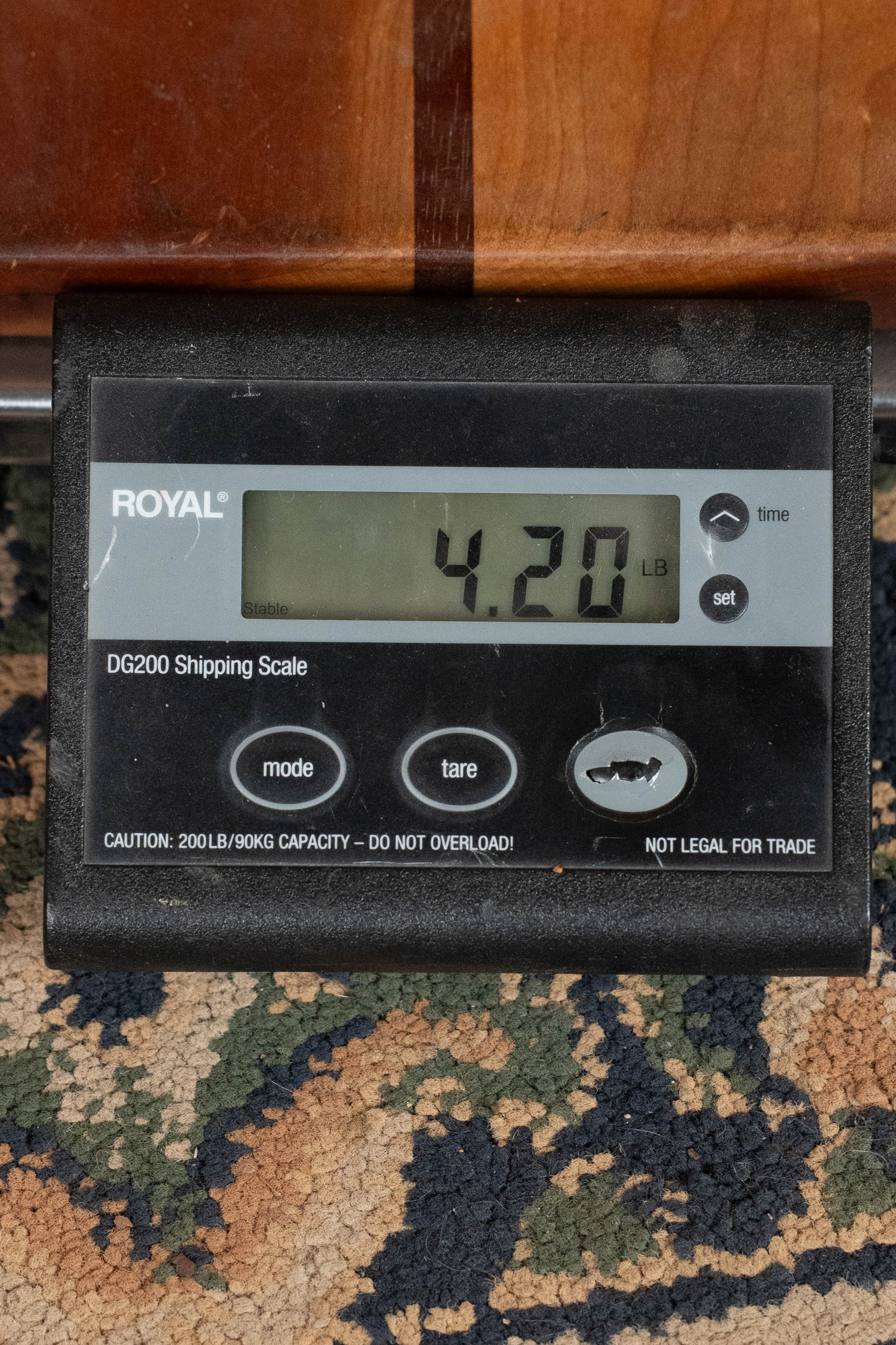 A digital shipping scale on a patterned carpet shows 4.20 pounds. The display reads ROYAL with buttons below—ideal for weighing your Eastman Guitars E1D Sitka/Sapele Dreadnought Acoustic Guitar #6855, featuring a solid Sitka spruce top.
