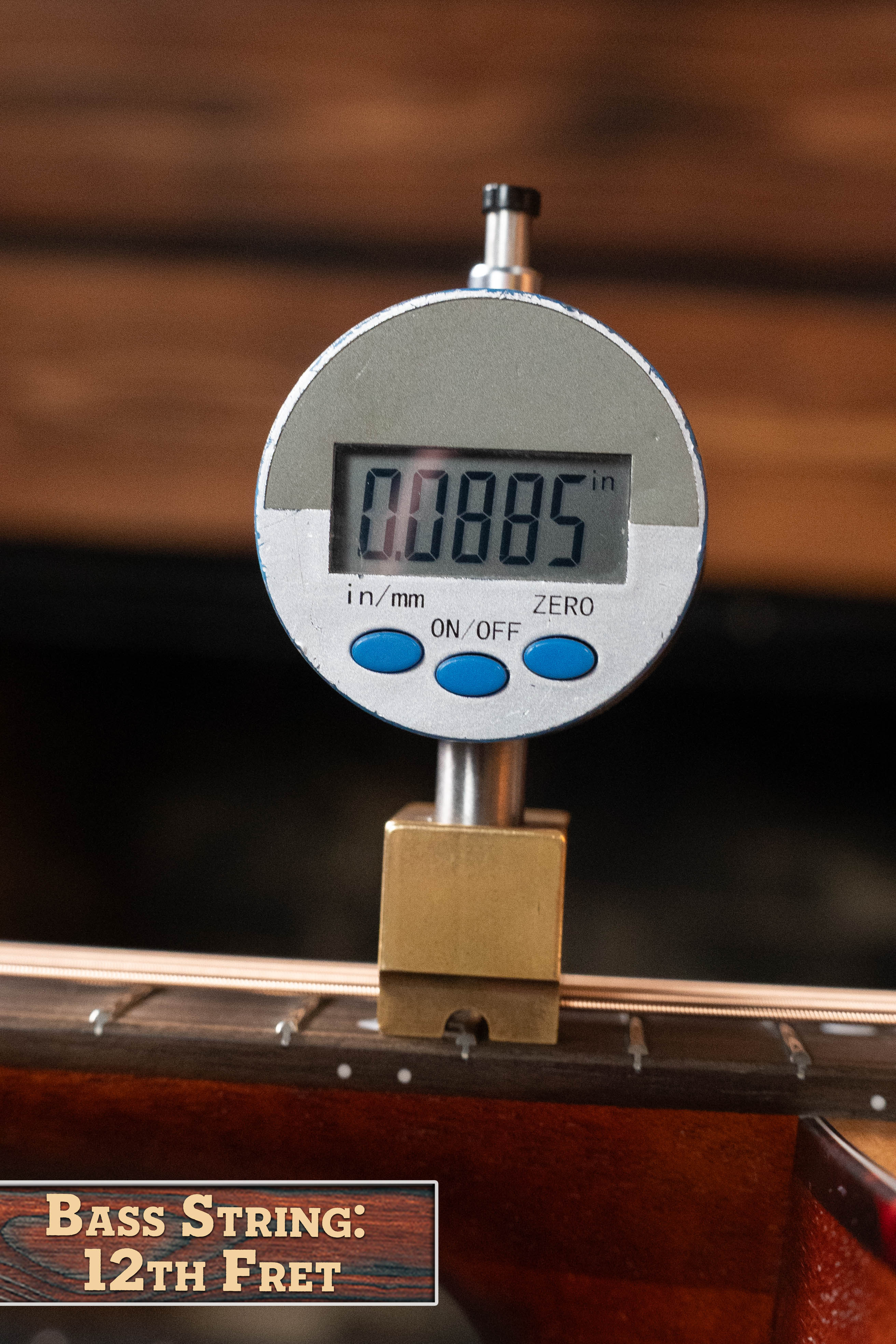 A digital gauge shows 0.0885 inches measuring bass string height at the 12th fret, labeled "Bass String: 12th Fret," similar to an Eastman Guitars E1OM All Solid Sitka/Sapele Orchestra Model Acoustic Guitar #7102 setup.