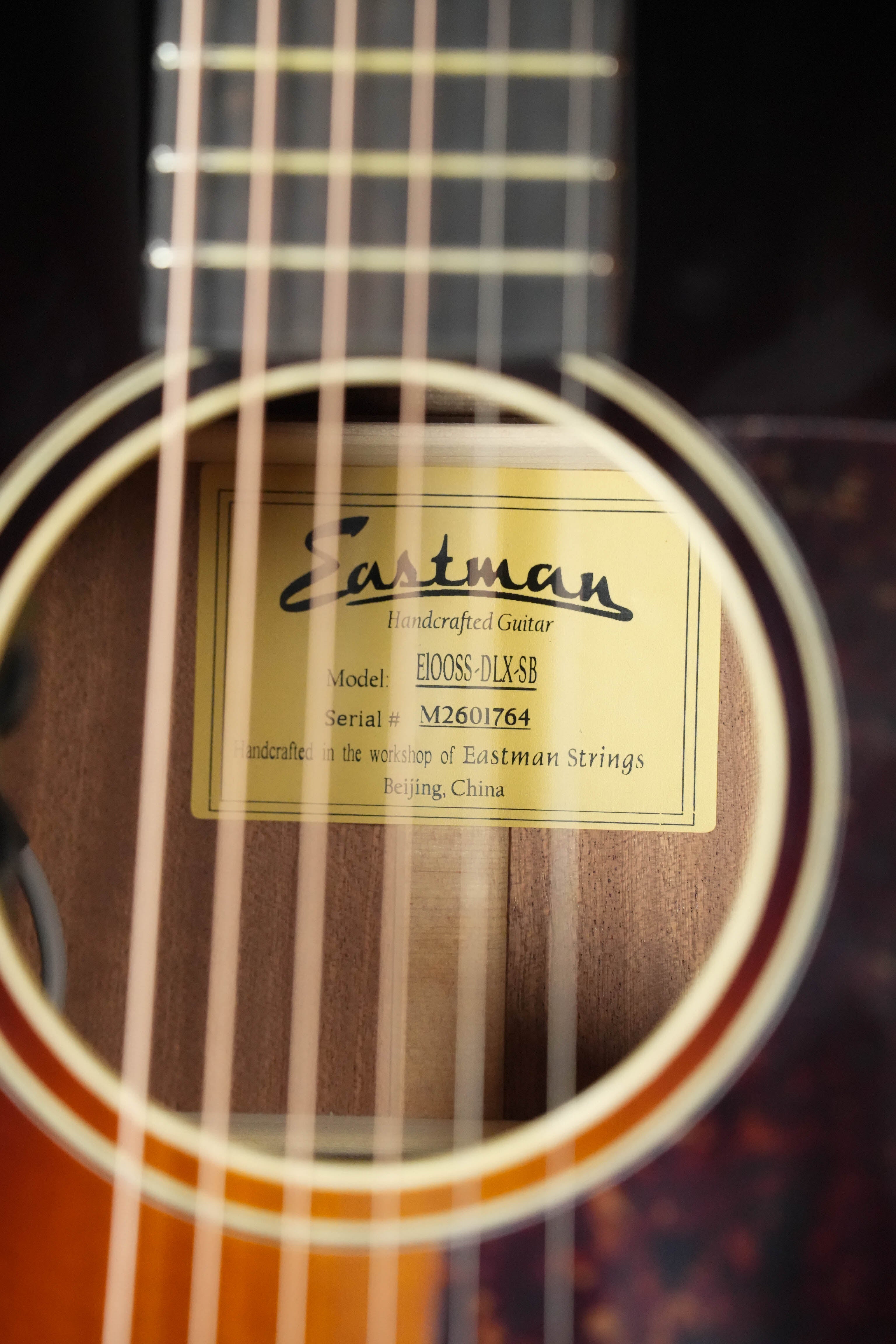 Close-up of the Eastman Guitars E1OOSS-DLX-SB Sunburst 00 Acoustic-Electric Guitar #1764 soundhole, showing the inside label with model and brand details.
