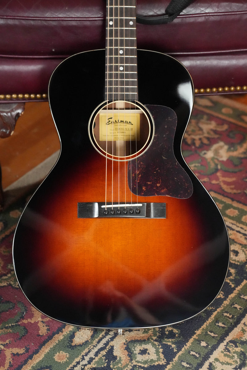 The Eastman E1OOSS-DLX-SB Sunburst 00 Acoustic-Electric Guitar #8804 by Eastman Guitars features a Truetone sunburst finish, six strings, and a tortoiseshell pickguard—classic pre-war vibes in a compact body.