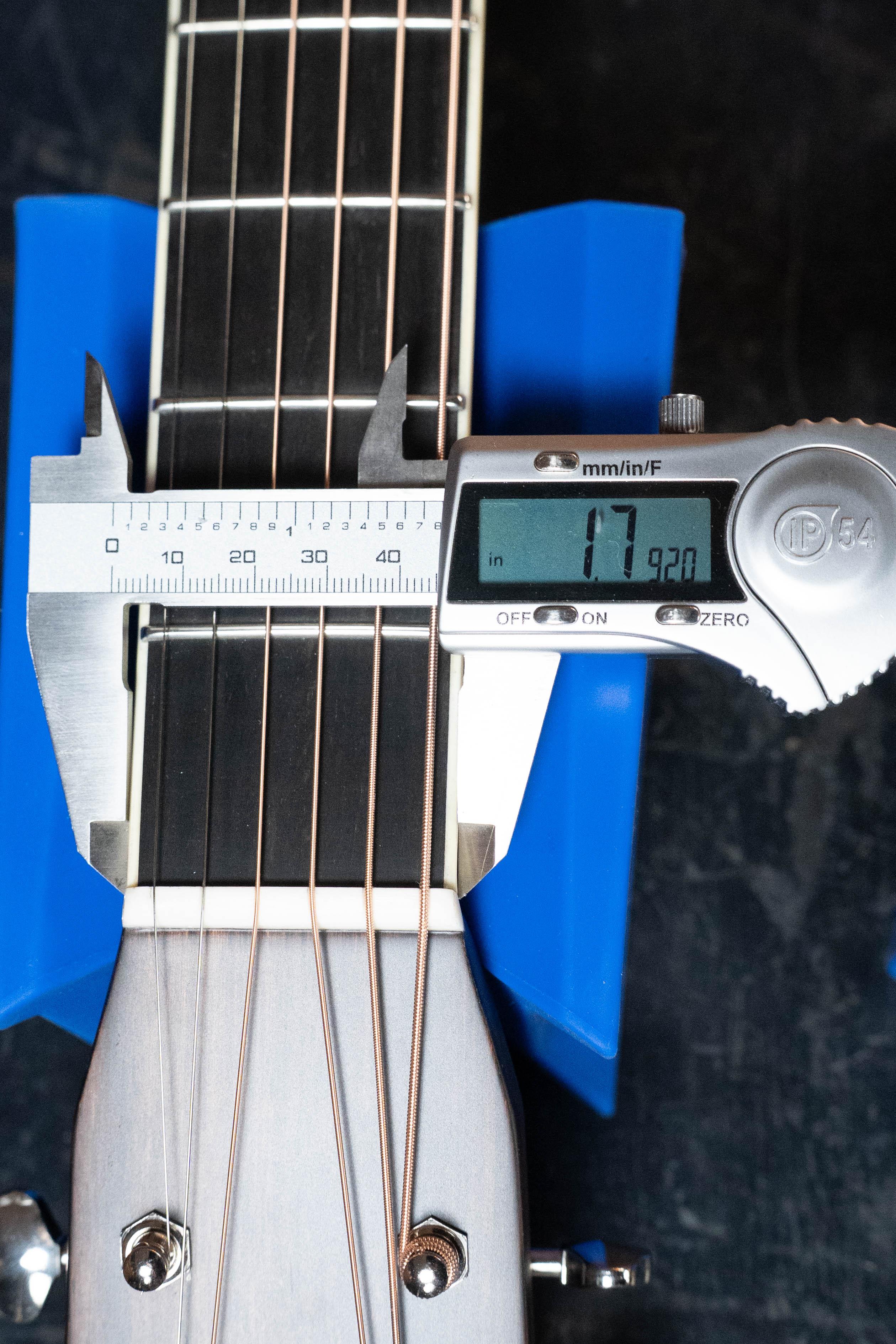 A digital caliper shows 1.792 inches while measuring the nut width of an Eastman Guitars E20D-LSH-TC Thermo-Cured Adirondack/Rosewood Large Soundhole Dreadnought Acoustic Guitar #3917, which rests on a blue support against a dark background.