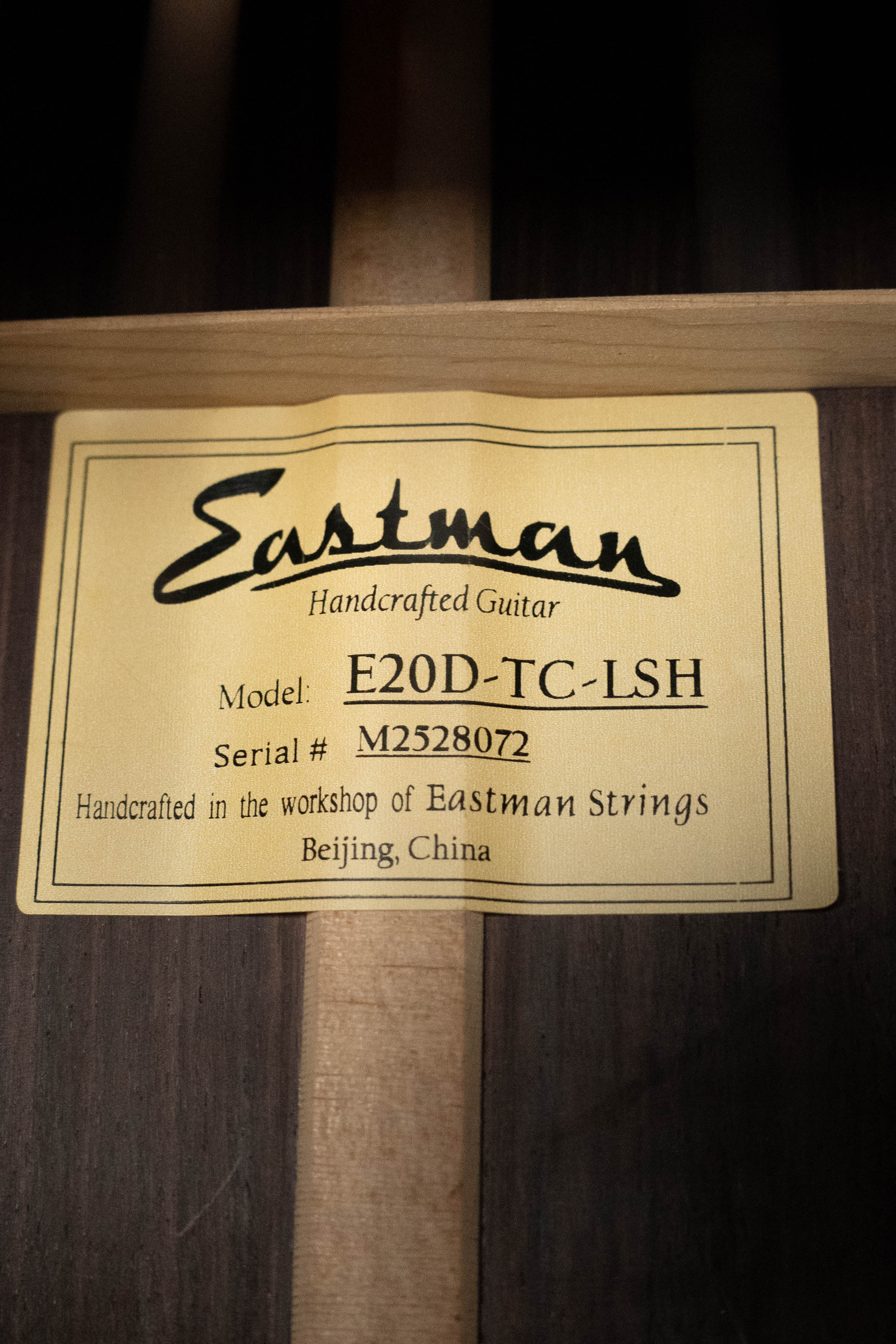 A close-up of a label inside an Eastman Guitars E20D-LSH-TC Thermo-Cured Adirondack/Rosewood Large Soundhole Dreadnought Acoustic Guitar #8072, handcrafted in Beijing, China.