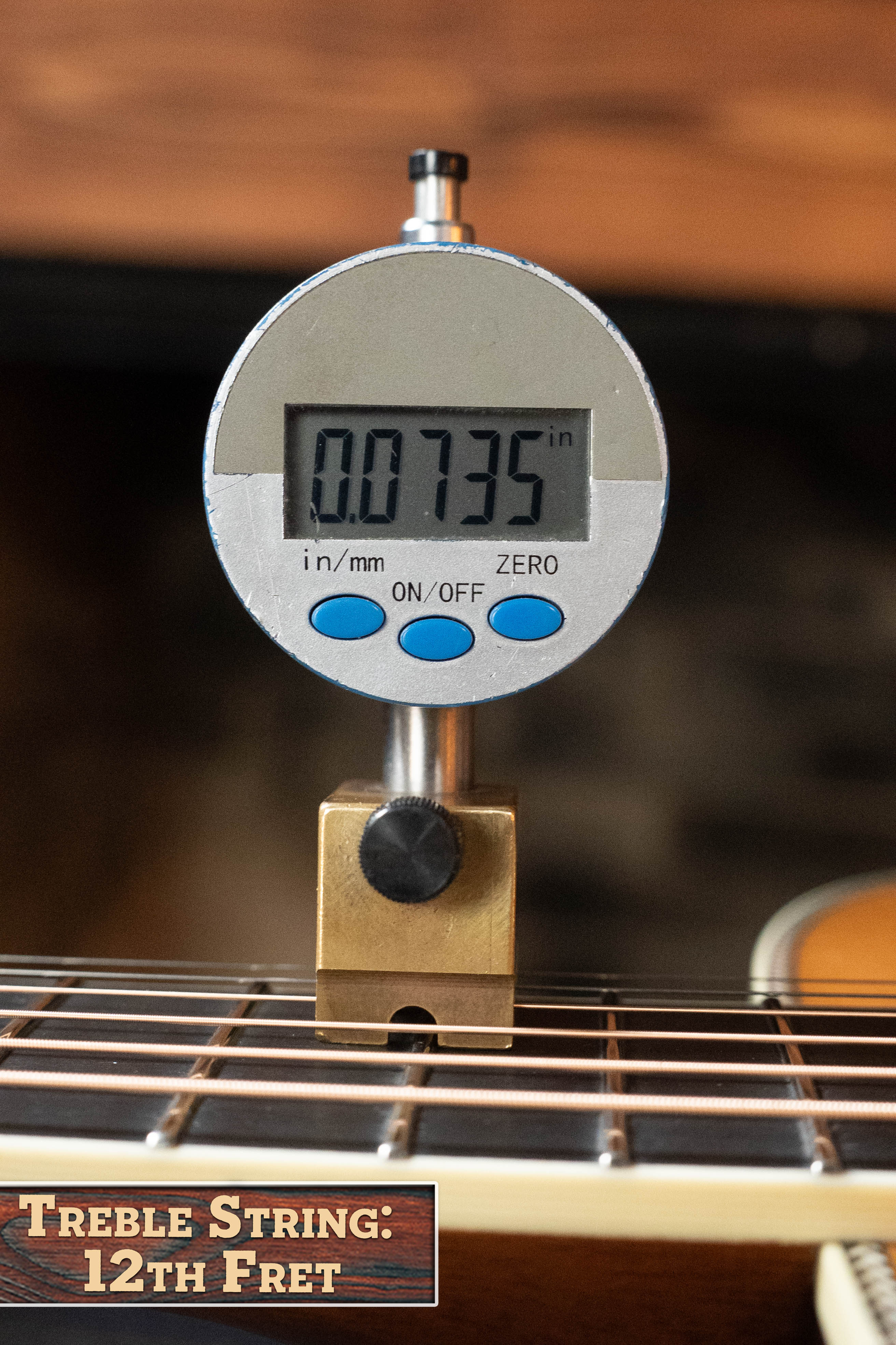 A digital gauge reads 0.0735 inches above the 12th fret treble string of an Eastman Guitars E20D-LSH-TC Thermo-Cured Adirondack/Rosewood Large Soundhole Dreadnought Acoustic Guitar #8072. The label says, "Treble String: 12th Fret.