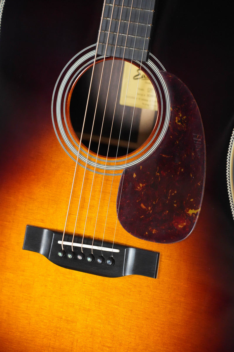 Close-up of the Eastman Guitars E20D-TC-SB Thermo-Cured Sunburst Dreadnought Acoustic Guitar #2946, showing its sunburst finish, torrefied Adirondack spruce top, sound hole, dark pickguard, strings, and bridge with six pegs.